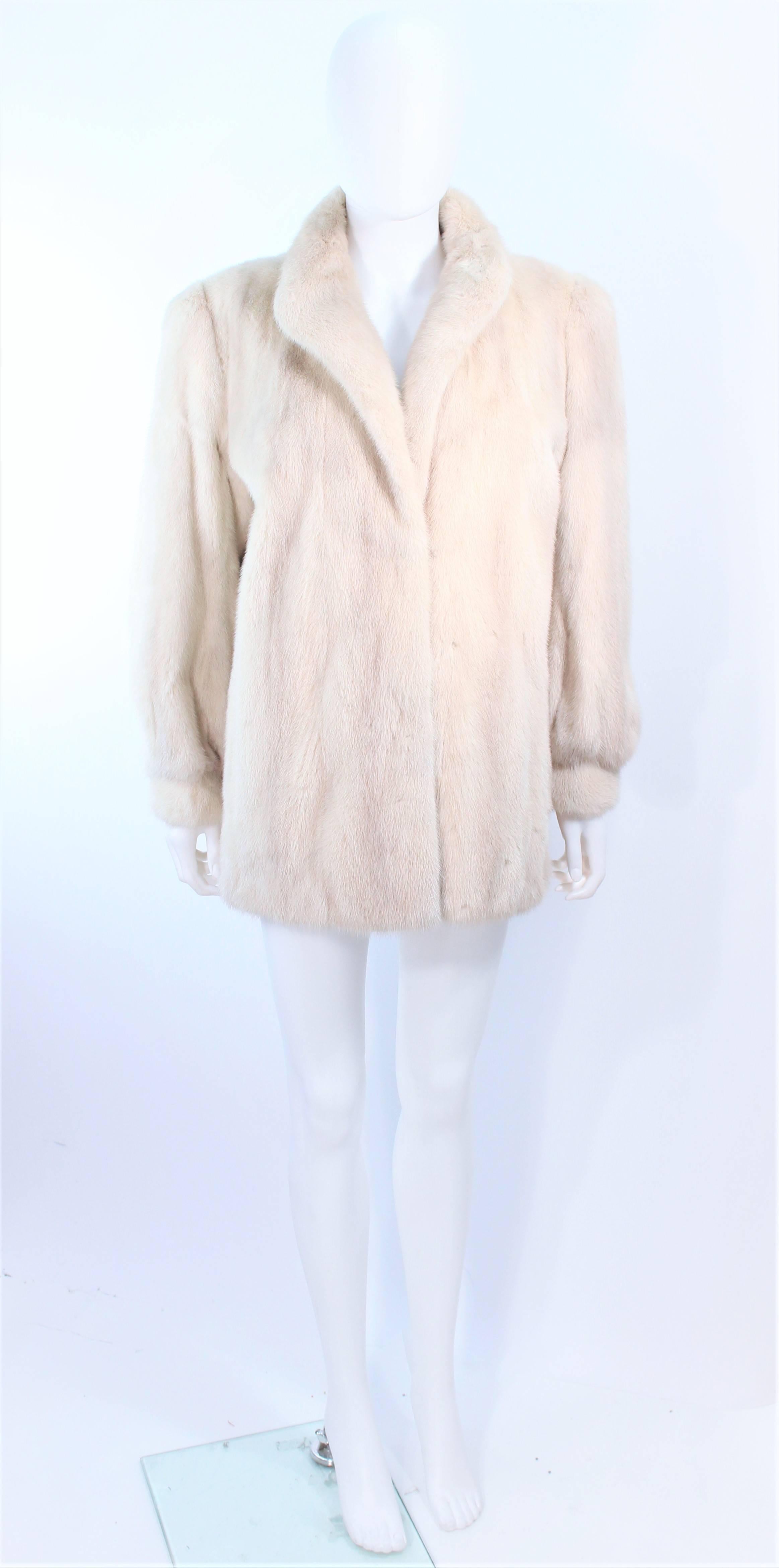 This Wactenheim coat is composed of a white mink, features velvet corduroy lined pockets. Interior silk lining with 