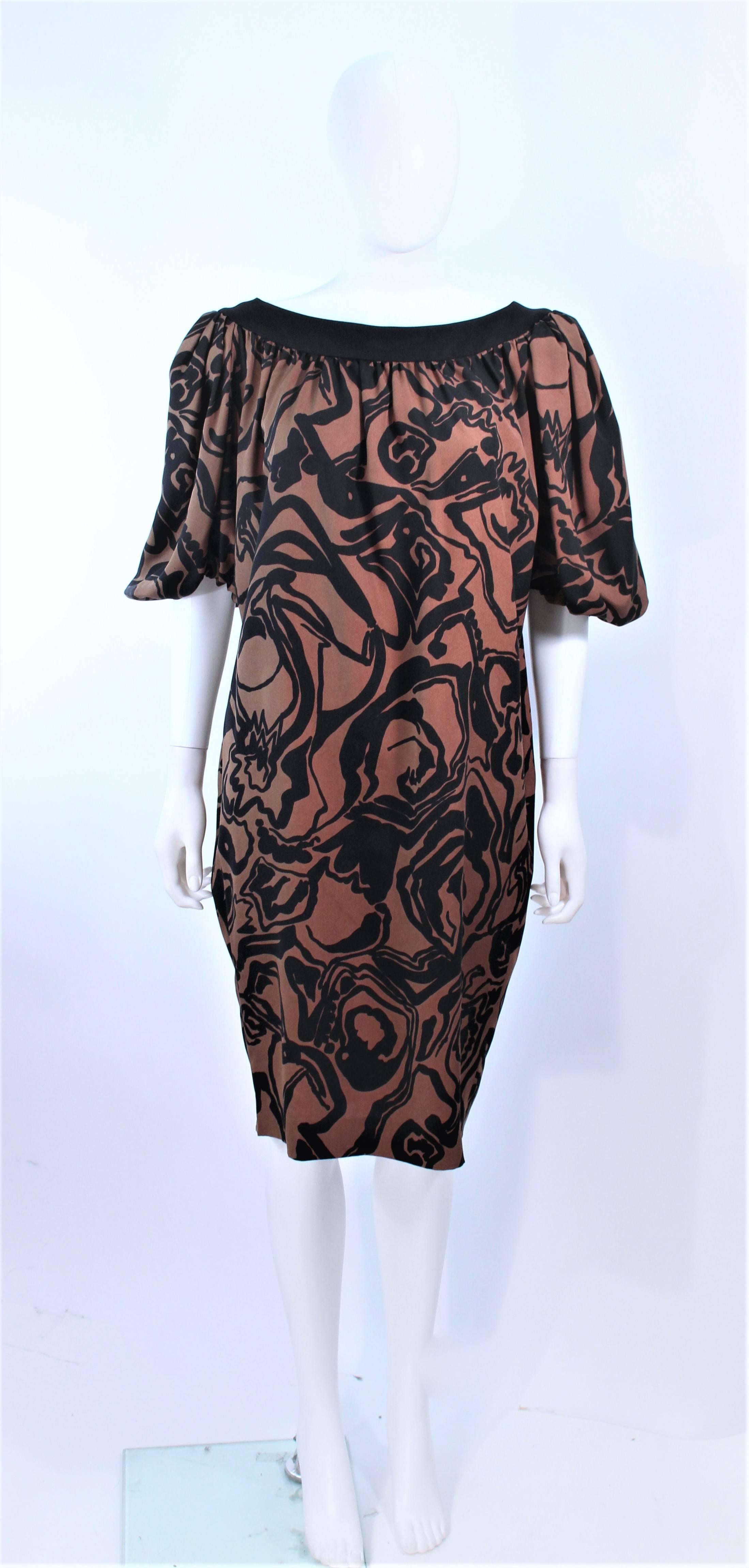 This Yves Saint Laurent dress is composed of a brown and black silk with an abstract floral pattern. Features large gathered puff sleeves. In excellent pre-owned condition.

**Please cross-reference measurements for personal accuracy. Size in