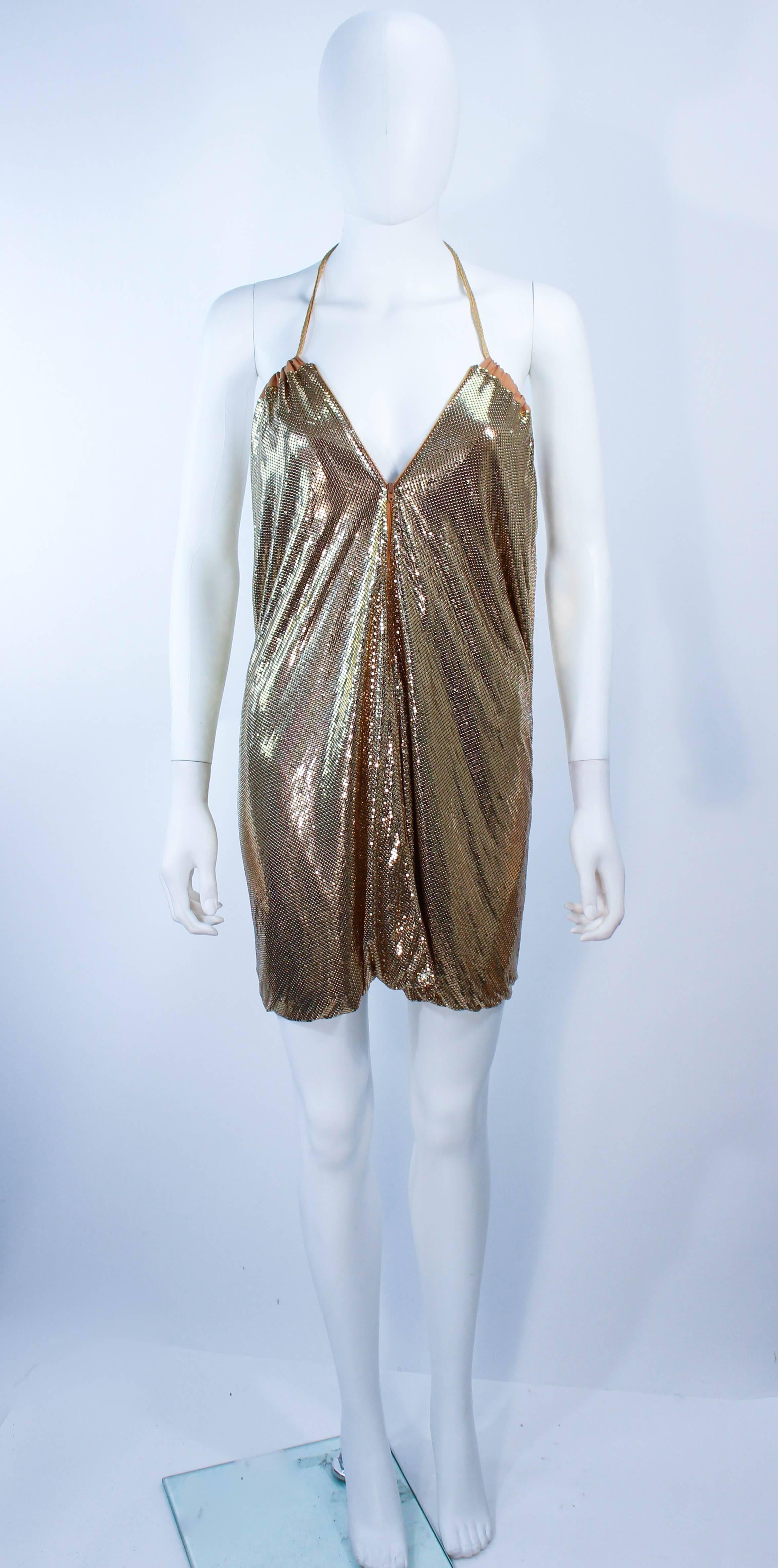 This Whiting and Davis design is composed of a gold mesh. This item can be fashioned as a draped halter dress or skirt. Features a zipper closure with drawstring tassel detail. In excellent vintage condition.

**Please cross-reference measurements