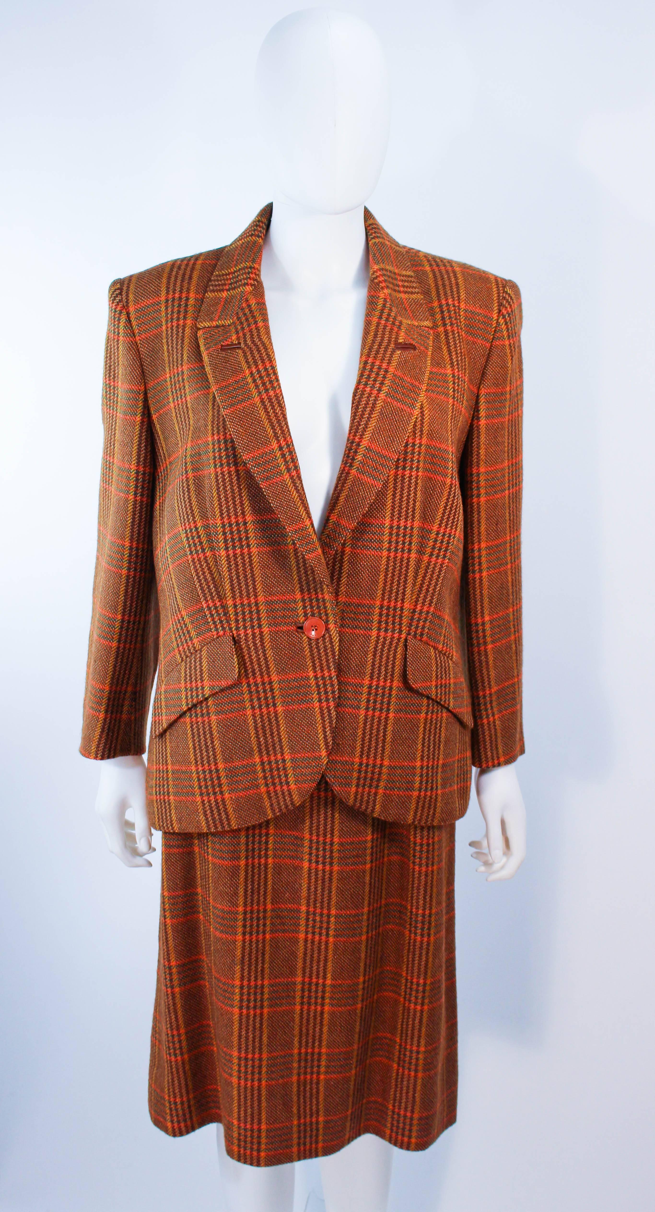 Ce tailleur jupe Hermès est composé d'une laine écossaise marron. La veste se ferme par un bouton central sur le devant. La jupe se ferme à l'aide d'une fermeture éclair. Vintage, en excellent état.

**Veuillez comparer les mesures pour vous assurer
