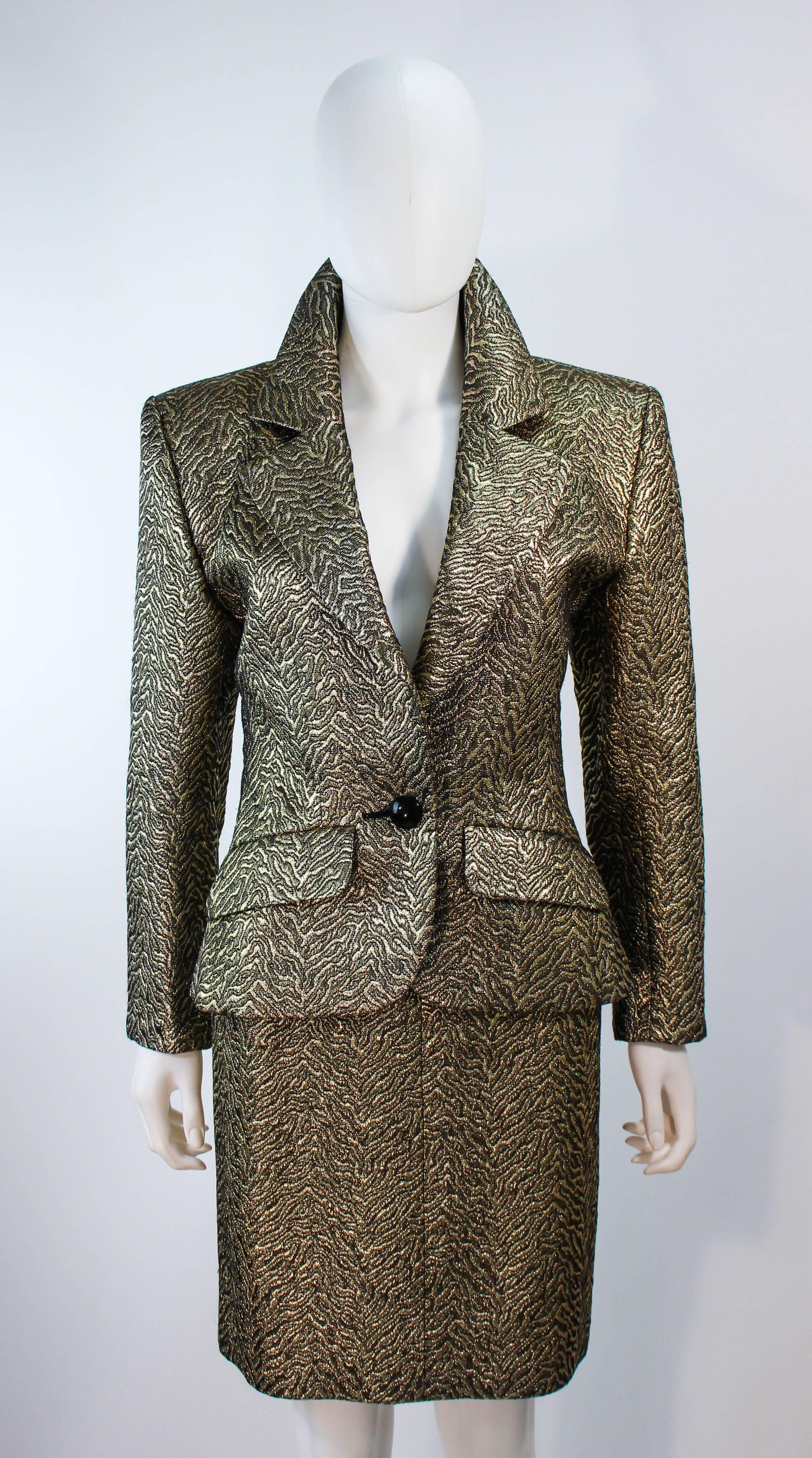 This Yves Saint Laurent skirt suit is composed of a gold and black lame, with an abstract animal print pattern. The jacket features a center front button closure. The skirt has a zipper closure. In excellent vintage condition.

**Please