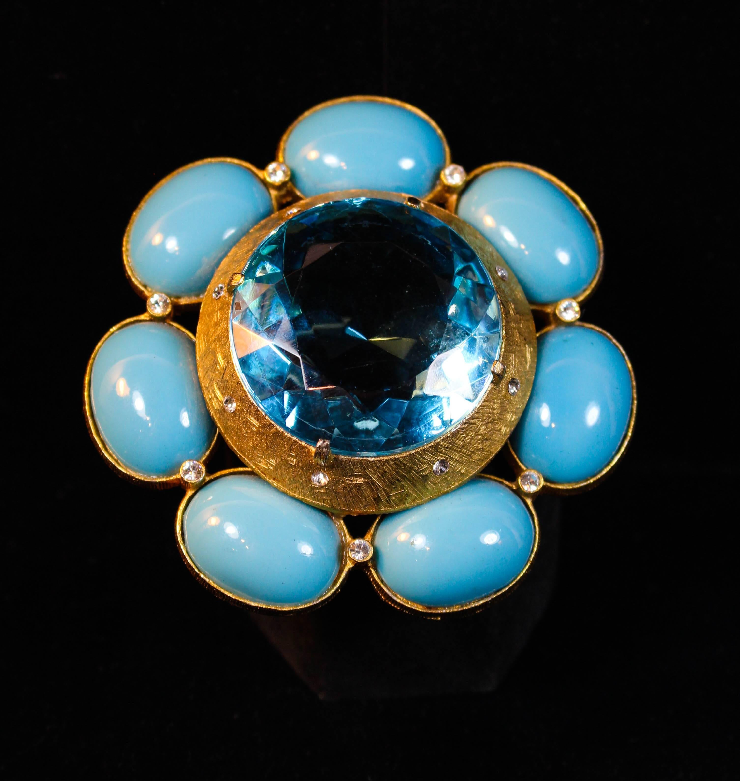 This Briana brooch is composed of a gold hue metal with a textured finished. Features an aqua colored center stone, flanked with turquoise stones, and rhinestone accents. In excellent vintage condition.

**Please cross-reference measurements for