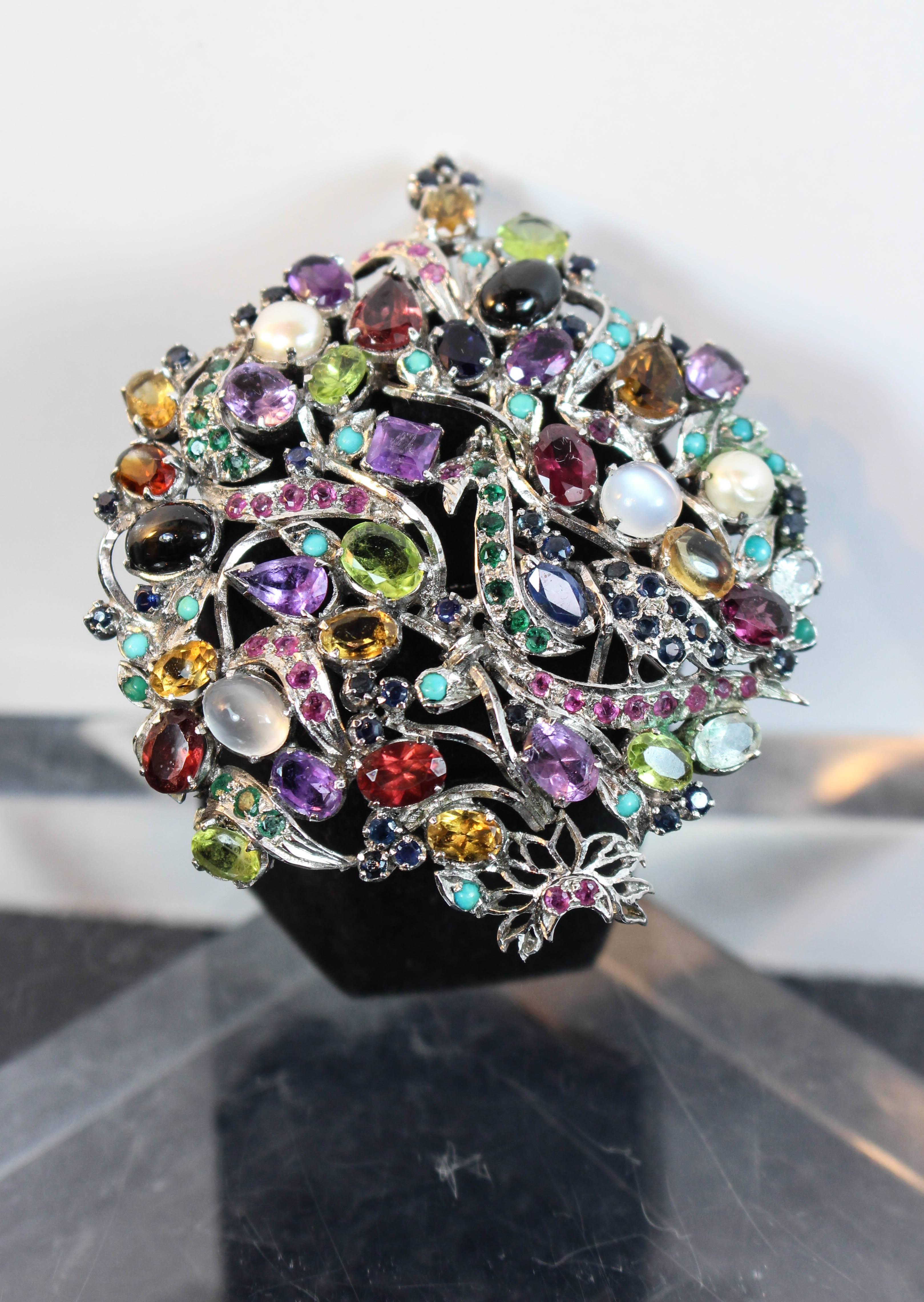 This brooch is composed of a silver hue metal set with semi precious stones. Can be styled as a brooch or pendant. In excellent vintage condition.

**Please cross-reference measurements for personal accuracy. Size in description box is an