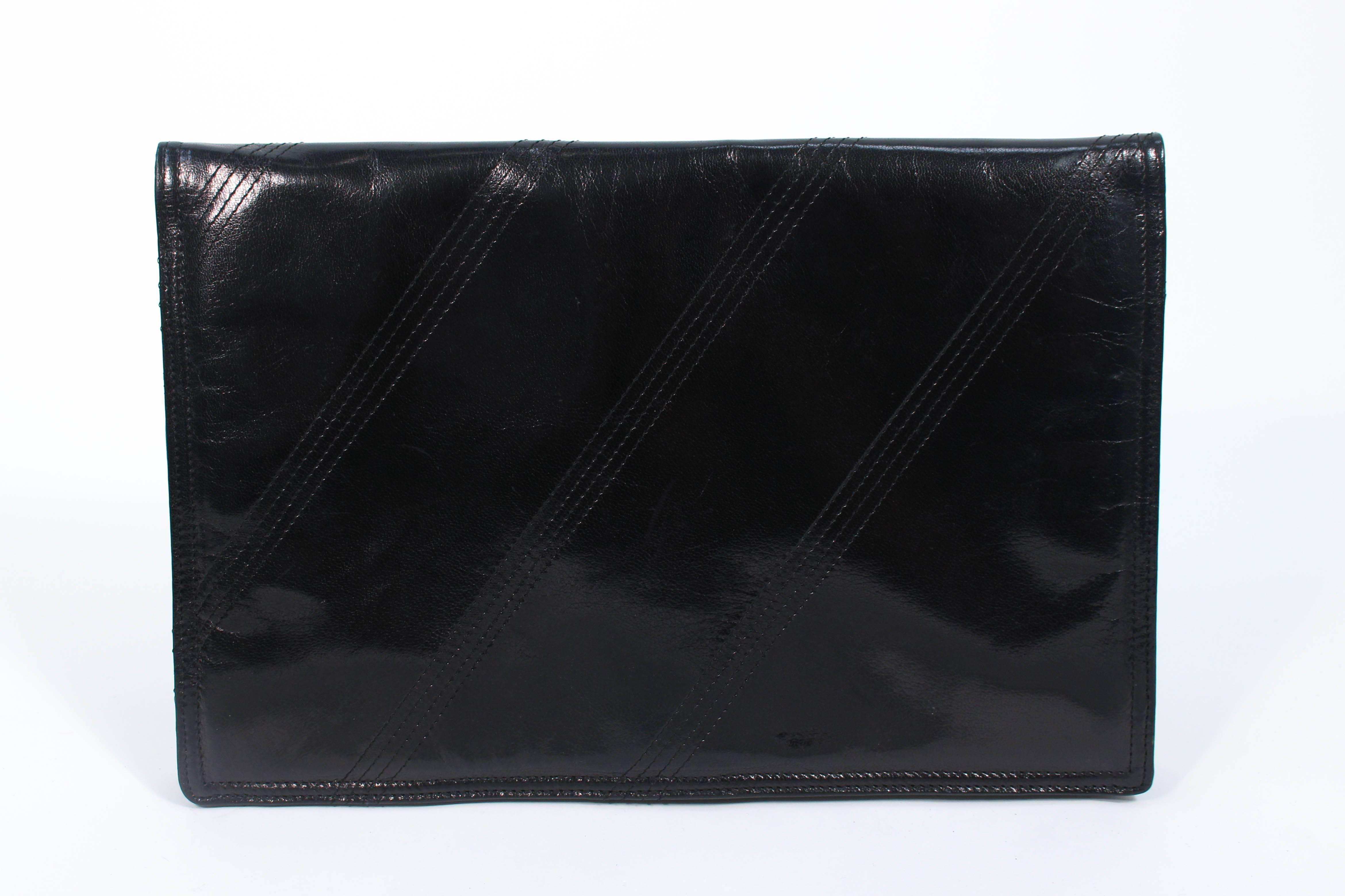 This Bottega Venta purse is composed of a polished black calfskin. Features top stitch details. There are multiple interior compartments as well as a zippered compartment. Made in France. In excellent vintage condition.

**Please cross-reference