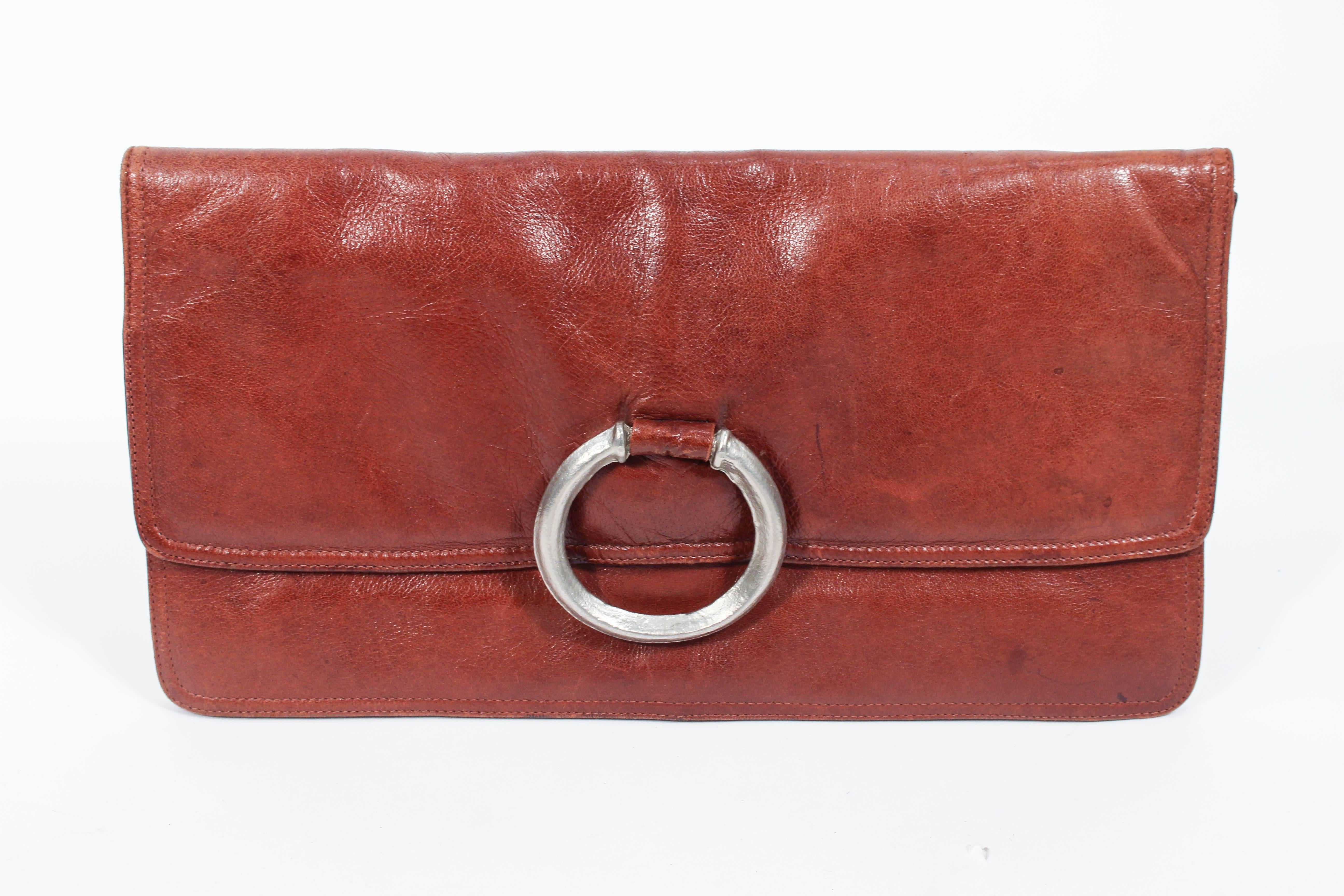 This Bottega Venta purse is composed of a beautiful cognac leather. Features a silver ring detail. There is an interior zip compartment. Made in France. In excellent vintage condition, some signs of wear due to age and use, but overall stunning