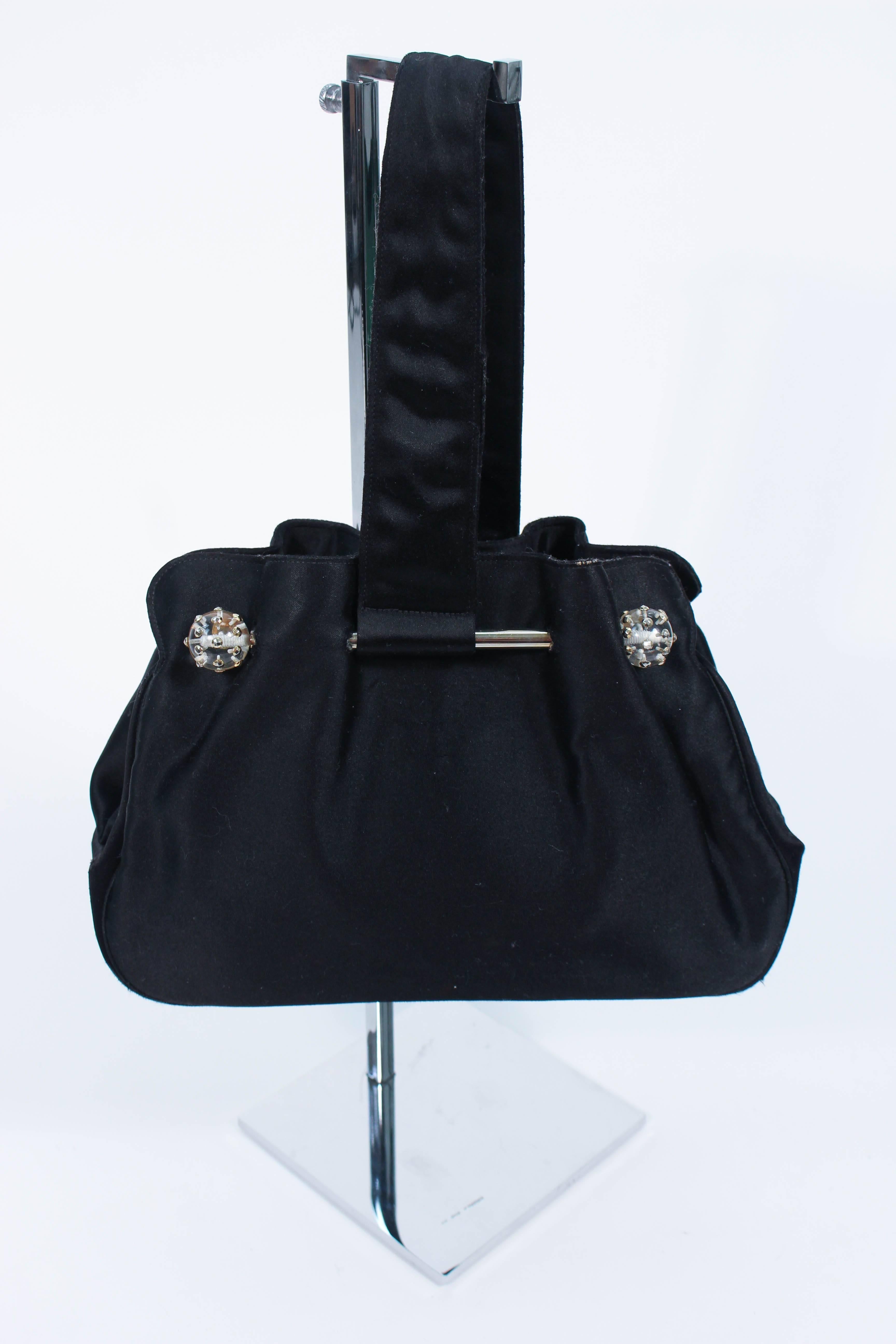 This vijntage 1950's purse is composed of black silk satin. Features lucite ball accents with inset rhinestones. There is an interior compartment with silk lining. In excellent vintage condition, comes with mirror.

**Please cross-reference