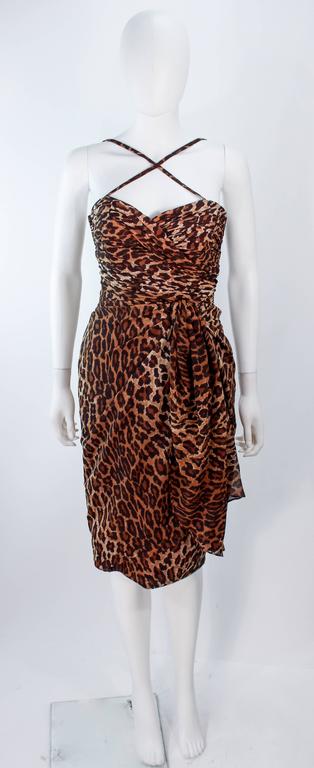 This Guy Laroche ensemble is composed of an animal print chiffon. The bustier features a stunning cut out back a with a criss-cross front, there is a zipper opening. The skirt has a zipper closure with drape front detail. In excellent vintage