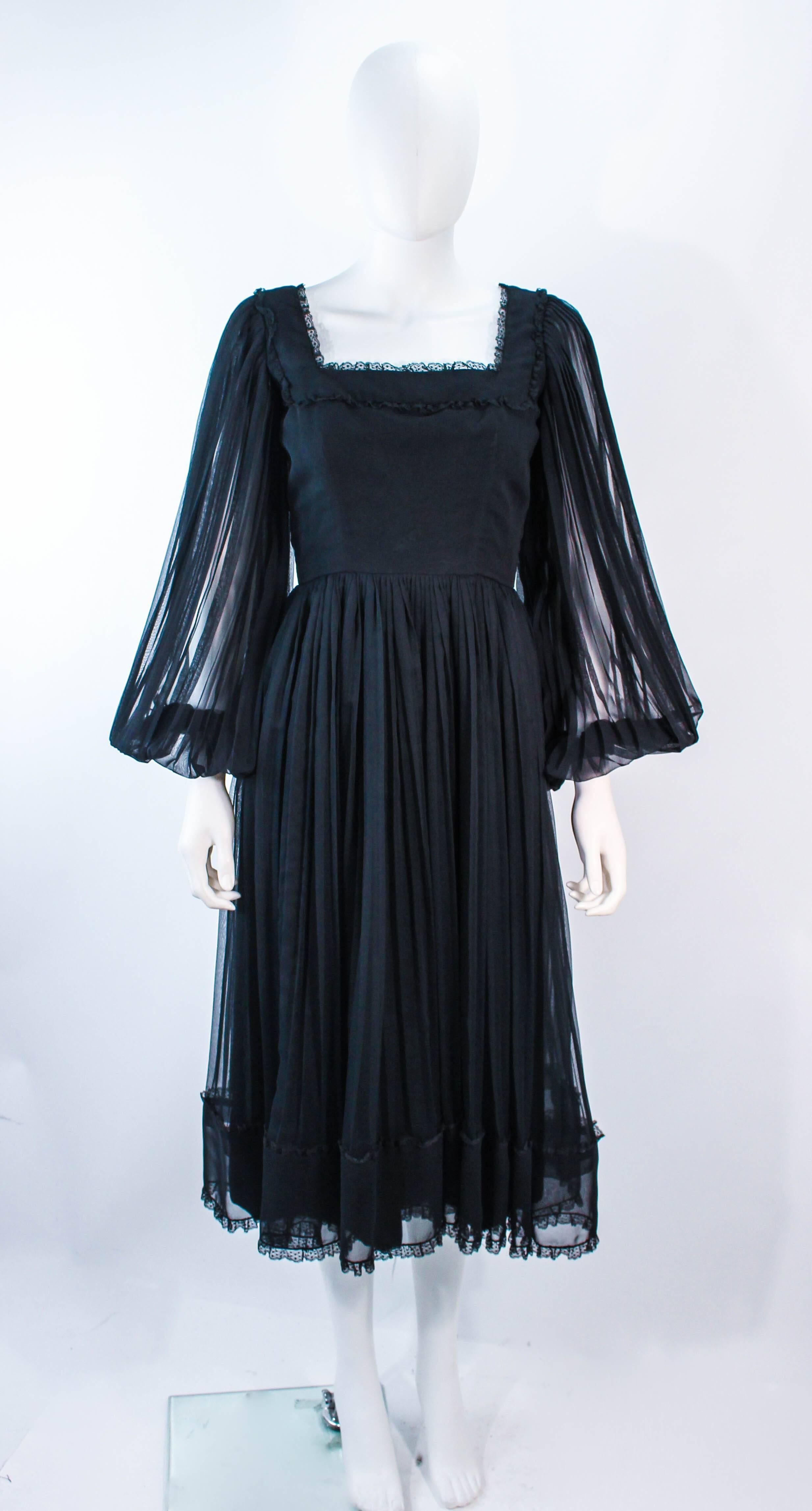 This Jean Louis dress is composed of a black sheer chiffon textured fabric with lace trim. Features pleated sheer sleeves with a beautiful square neckline. There is a center back zipper closure. In excellent condition. 

**Please cross-reference