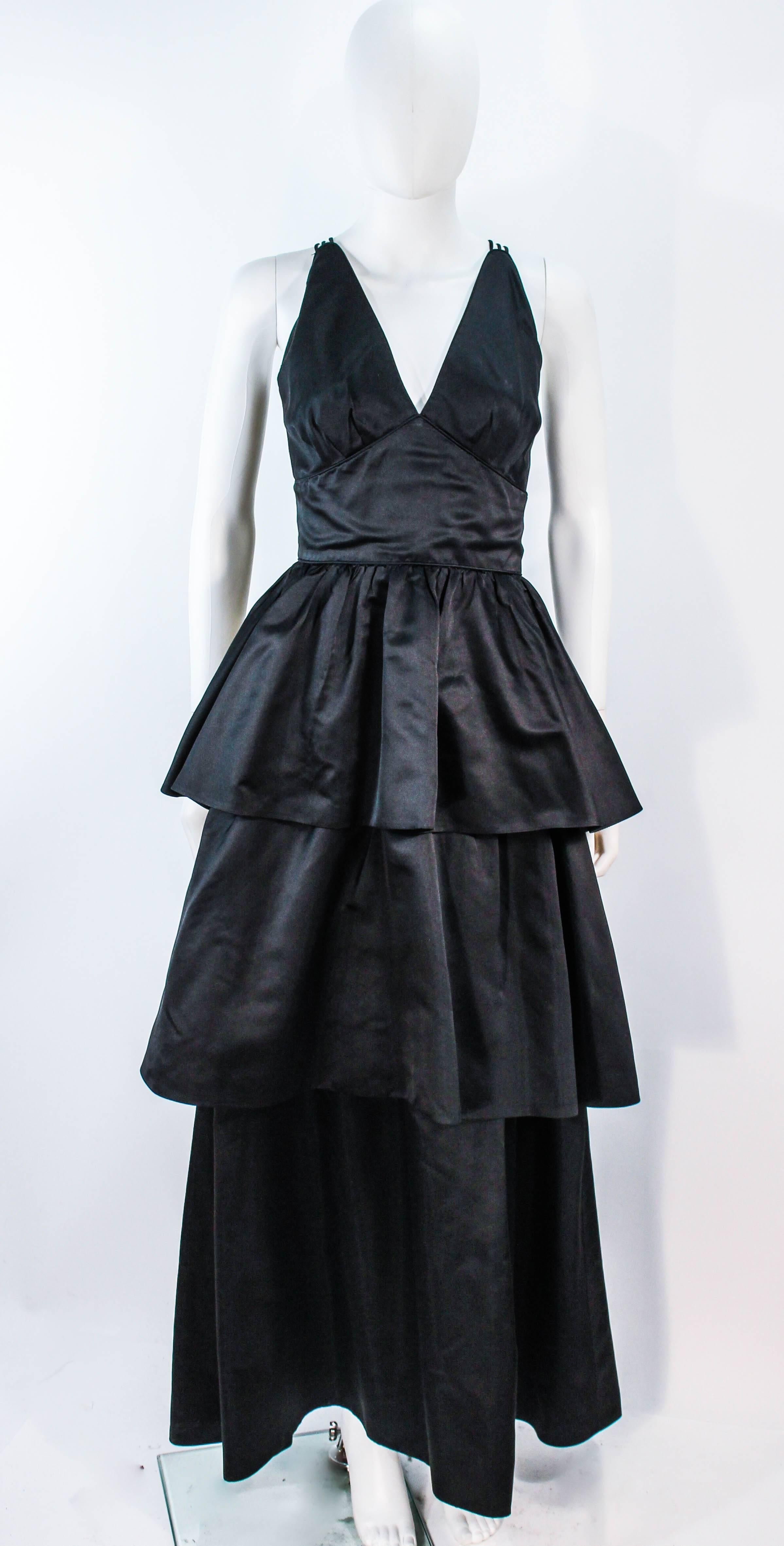 This Michael Novarese gown and jacket is composed of a black satin. The jacket has center front button closures. The gown has a multi strap design with center back zipper closure. In excellent condition. 

**Please cross-reference measurements for