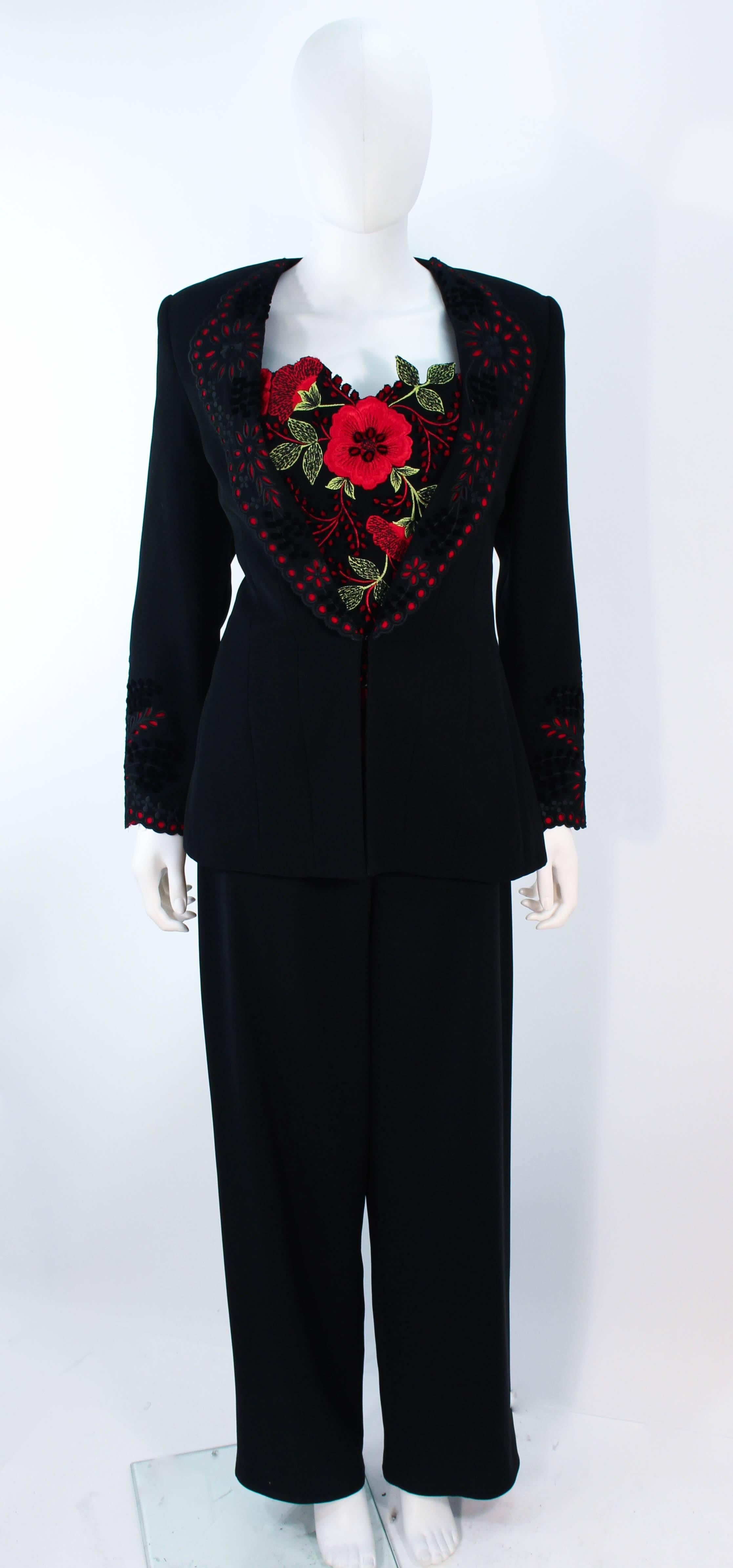 This Fe Zandi suit is composed of a black fabric with red lac/ eyelet accents. Features a stunning floral bustier with a center back zipper closure. The jacket has a lace trim collar with hook and eye closure. The pants have a side zipper closure.