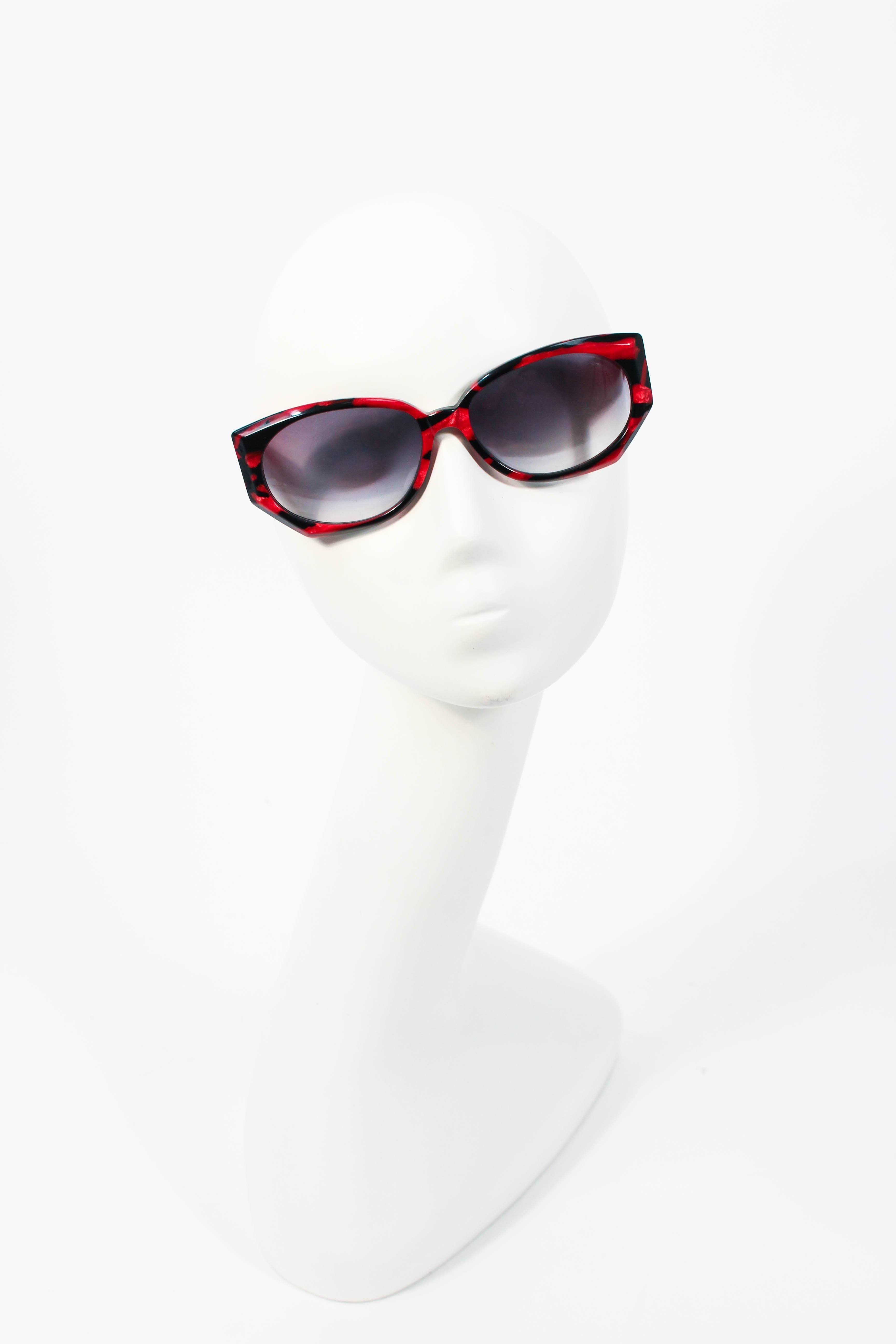 Ces lunettes de soleil Krizia sont composées d'un plastique marbré noir et rouge. Elle est dotée d'un superbe cadre large et d'un design chic et tendance. En excellent état vintage.

**Veuillez comparer les mesures pour vous assurer de leur