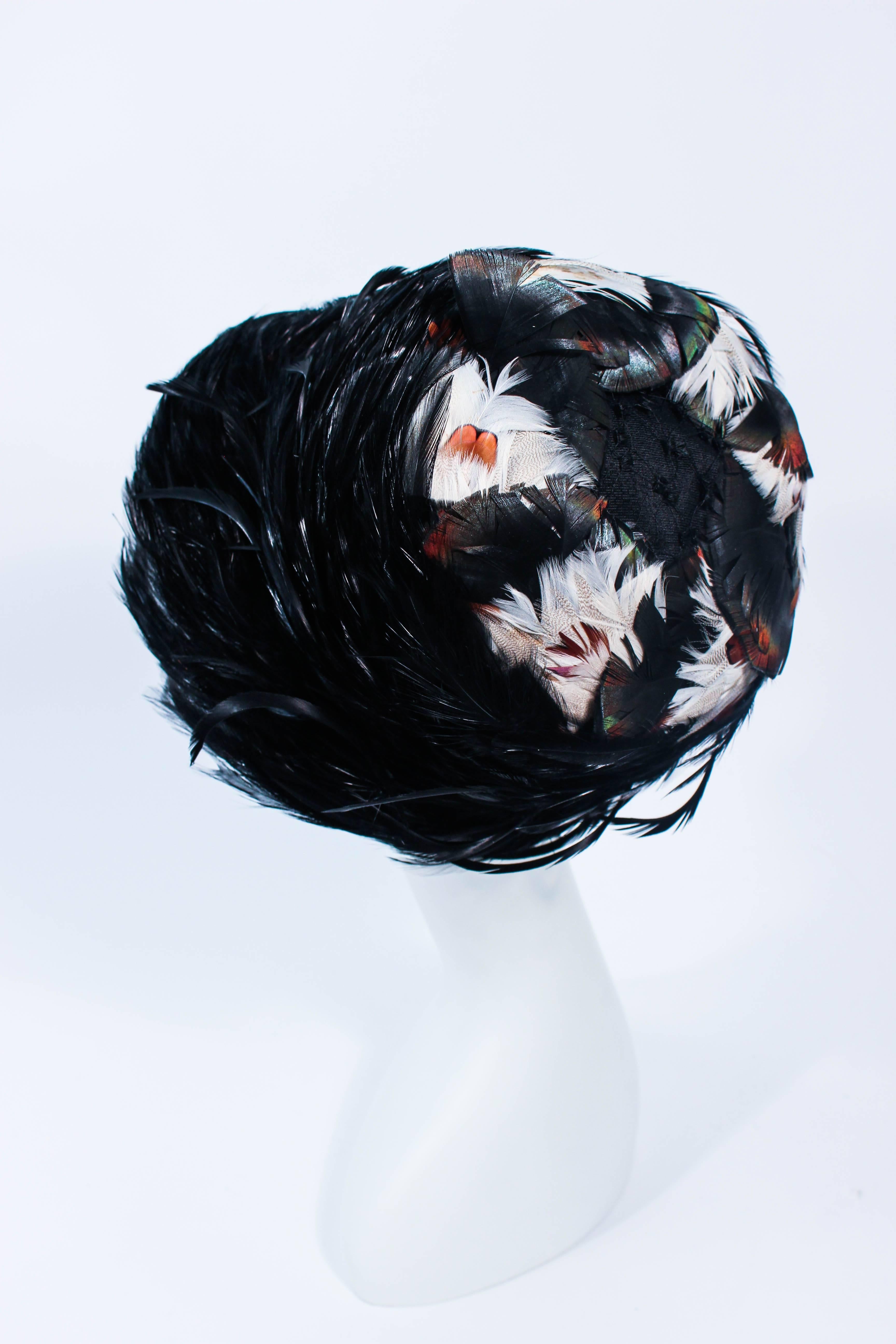 This Christian Dior hat is composed of a wonderful blend of black and cream feathers. Features a vibrant swooping swirl feather design. Made in France. 

Measures (Approximately)
Circumference: 20 7/8