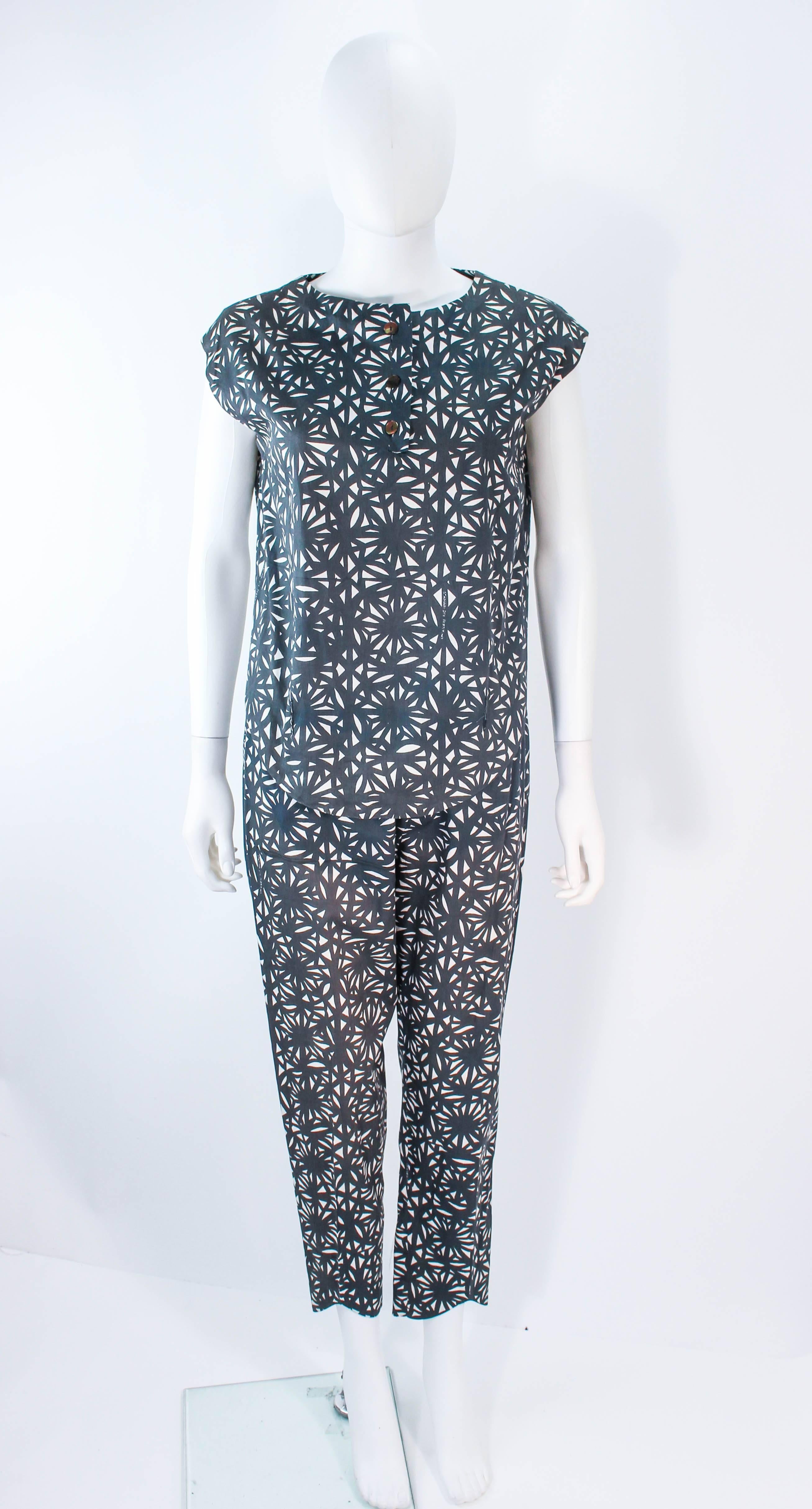 This vintage Gianni Baldini set is composed of  pure printed cotton. Features a top and matching pants that connect together with large white buttons. The pants have a zipper closure and the blouse has center front button closures. In excellent