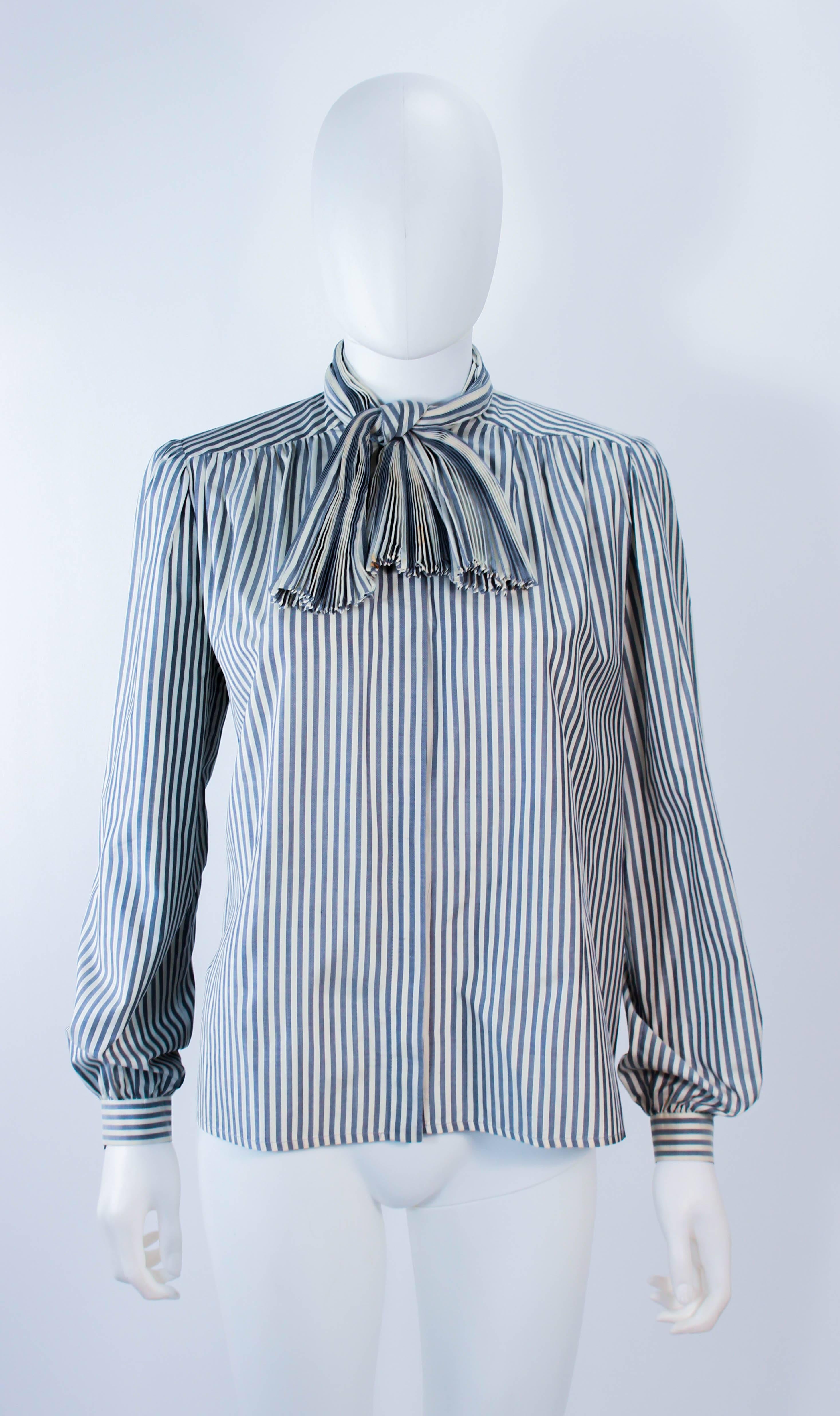 This vintage Valentino blouse is composed of a blue and white pinstripe fabric. Features a pleated pussy bow detail with center front button closures. In good vintage condition, the bow has some staining (see photos) excellent for design