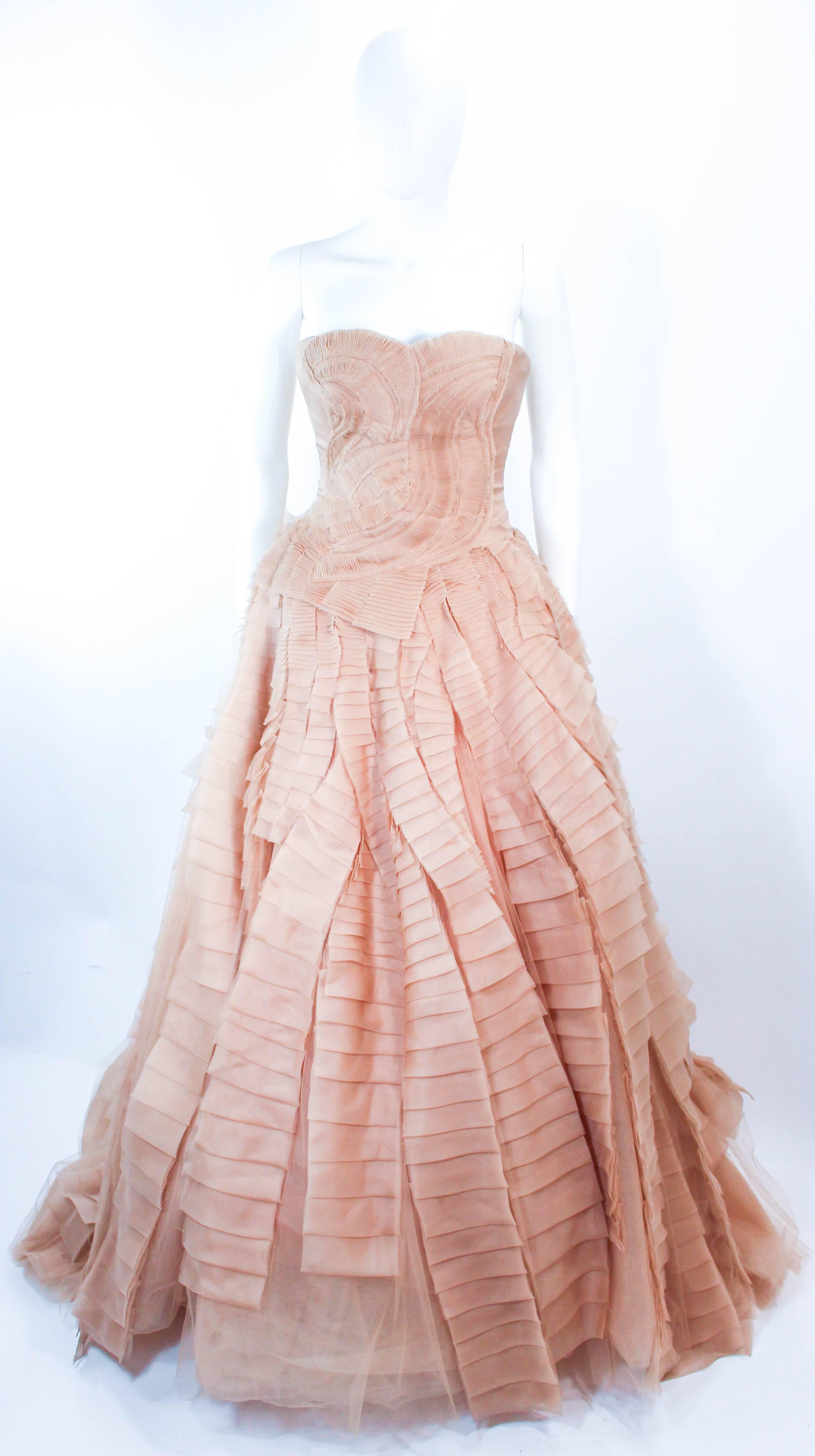 This Vera Wang wedding gown is composed of layers of nude organza and tulle. The bodice features a gathered detailing with a boned interior and center back zipper closure. In excellent pre-owned condition (there are a few faint spots due to