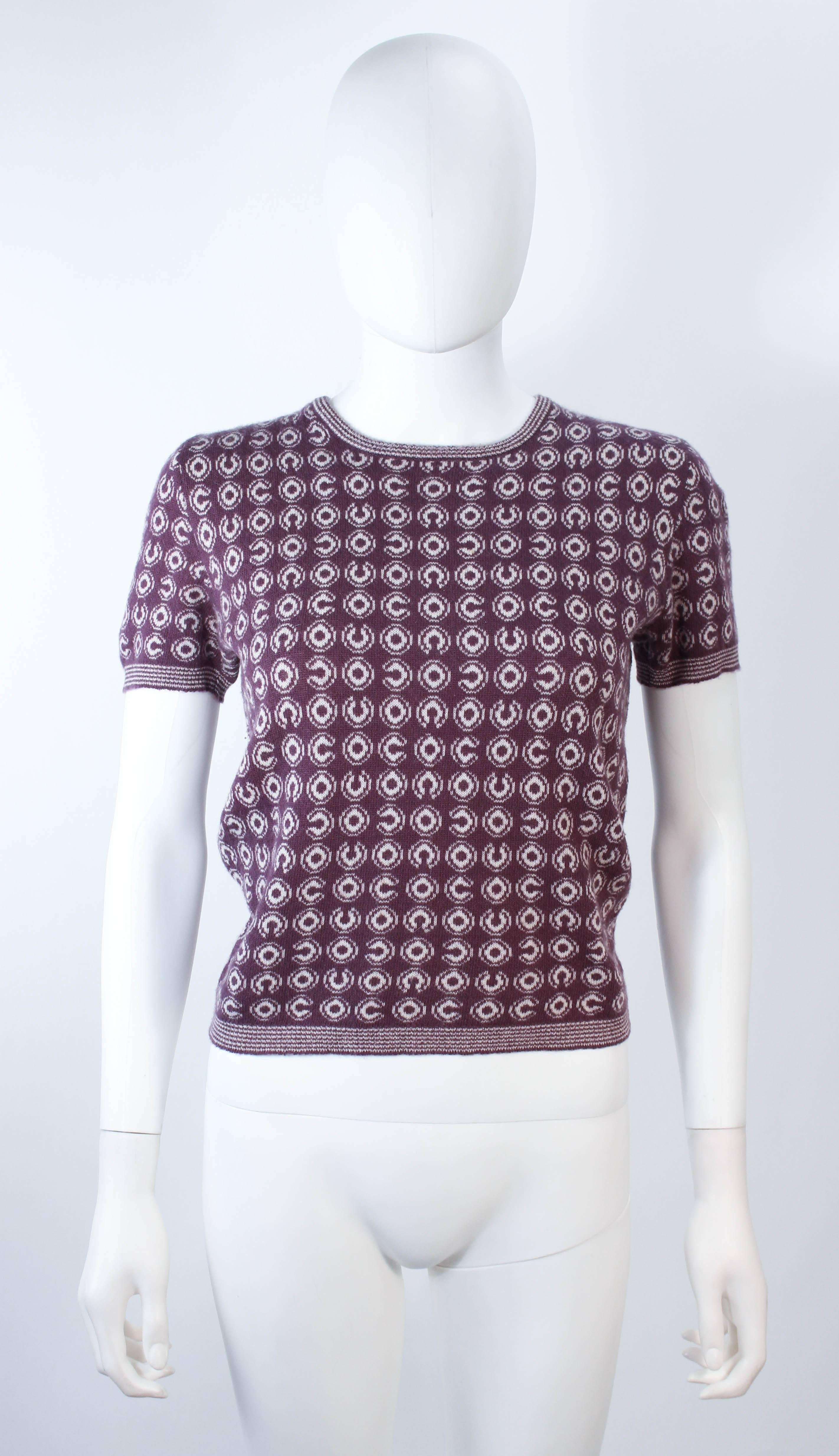 This Chanel sweater is composed of a burgundy and cream cashmere blend. Features a short sleeve style with 