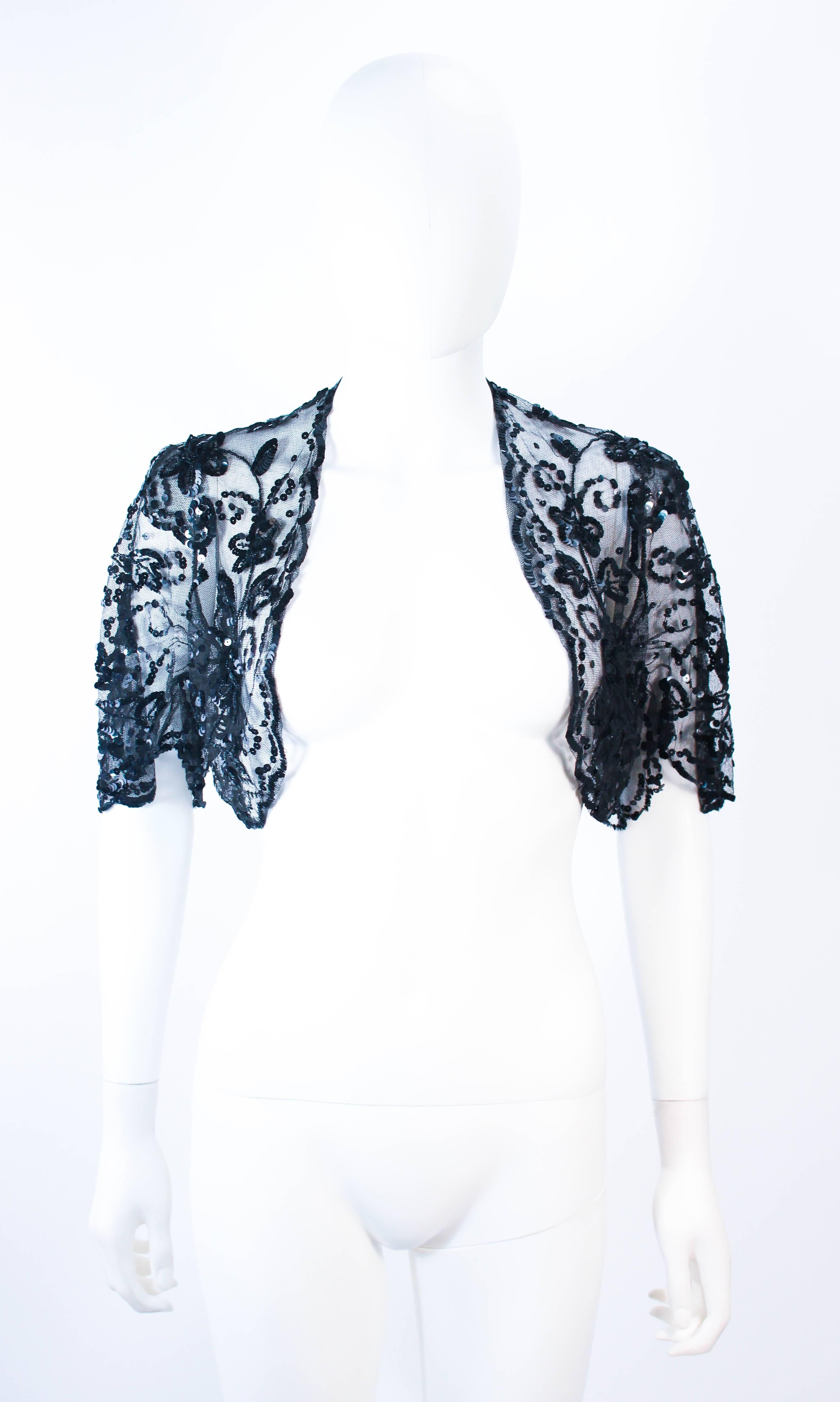 This antique jacket is composed of a sheer black mesh with black sequin applique. Features an open style with a drape style sleeve. In excellent vintage condition. 

**Please cross-reference measurements for personal accuracy. Size in description
