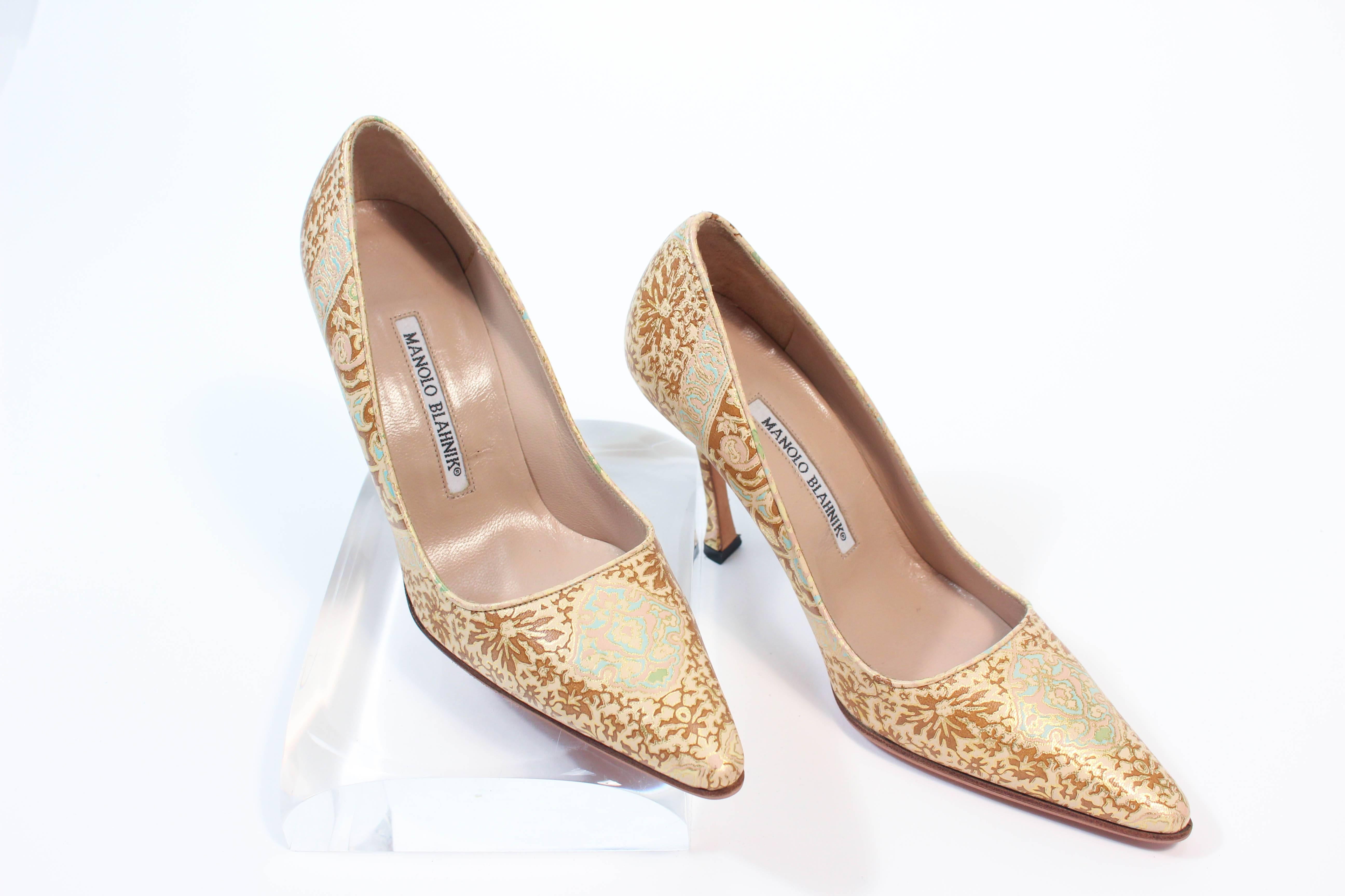 These Manolo Blahnik high heels are composed of a gold brocade leather with white and turquoise accents. Features a pointed toe with stiletto heel . In excellent unused condition. 

**Please cross-reference measurements for personal accuracy. Size