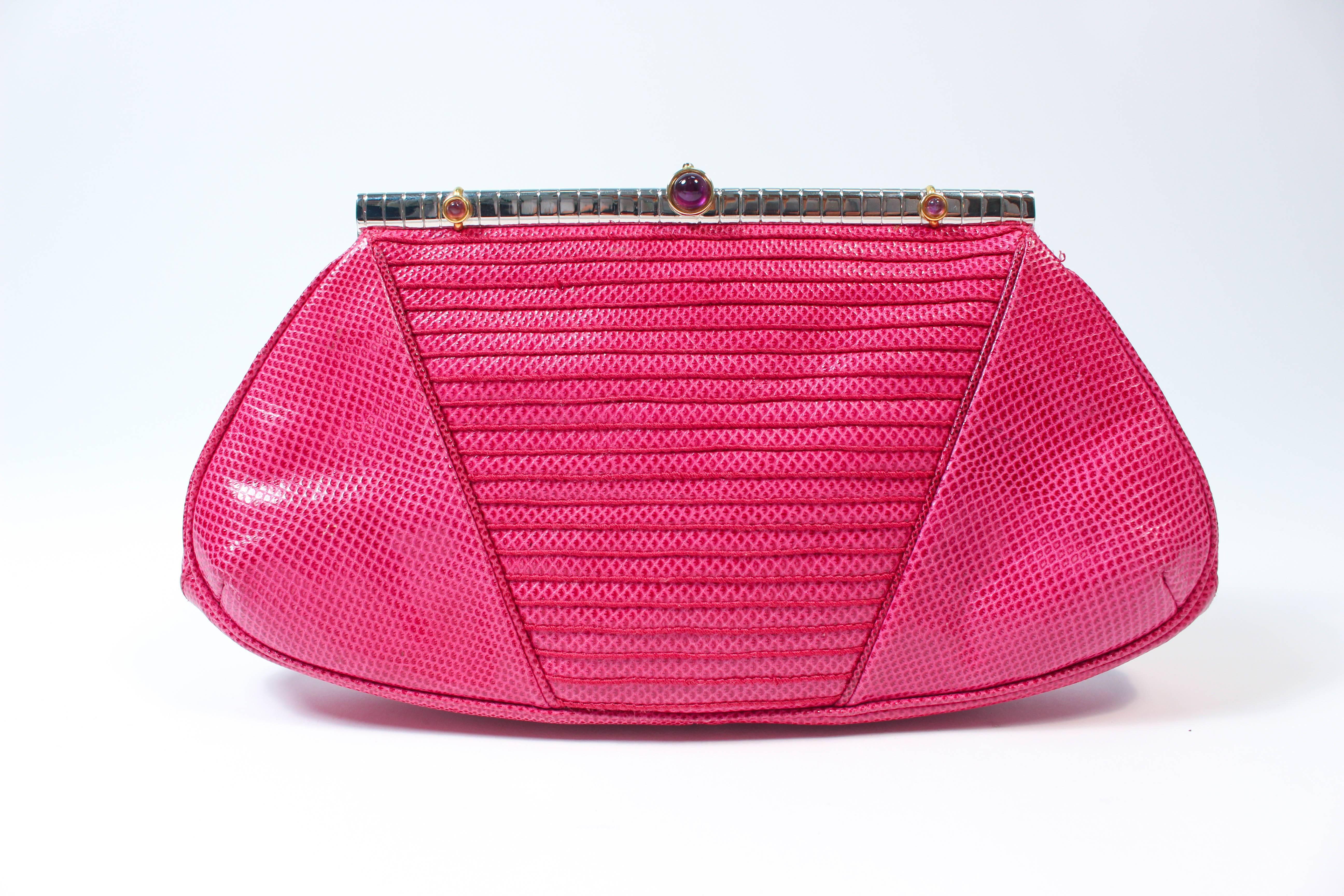 This  Judith Leiber vintage purse is composed of a magenta pink lizard skin, Features a frame style with optional chain strap which can be worn as a cross-body and clutch. There is an interior zipper compartment. In excellent vintage condition comes