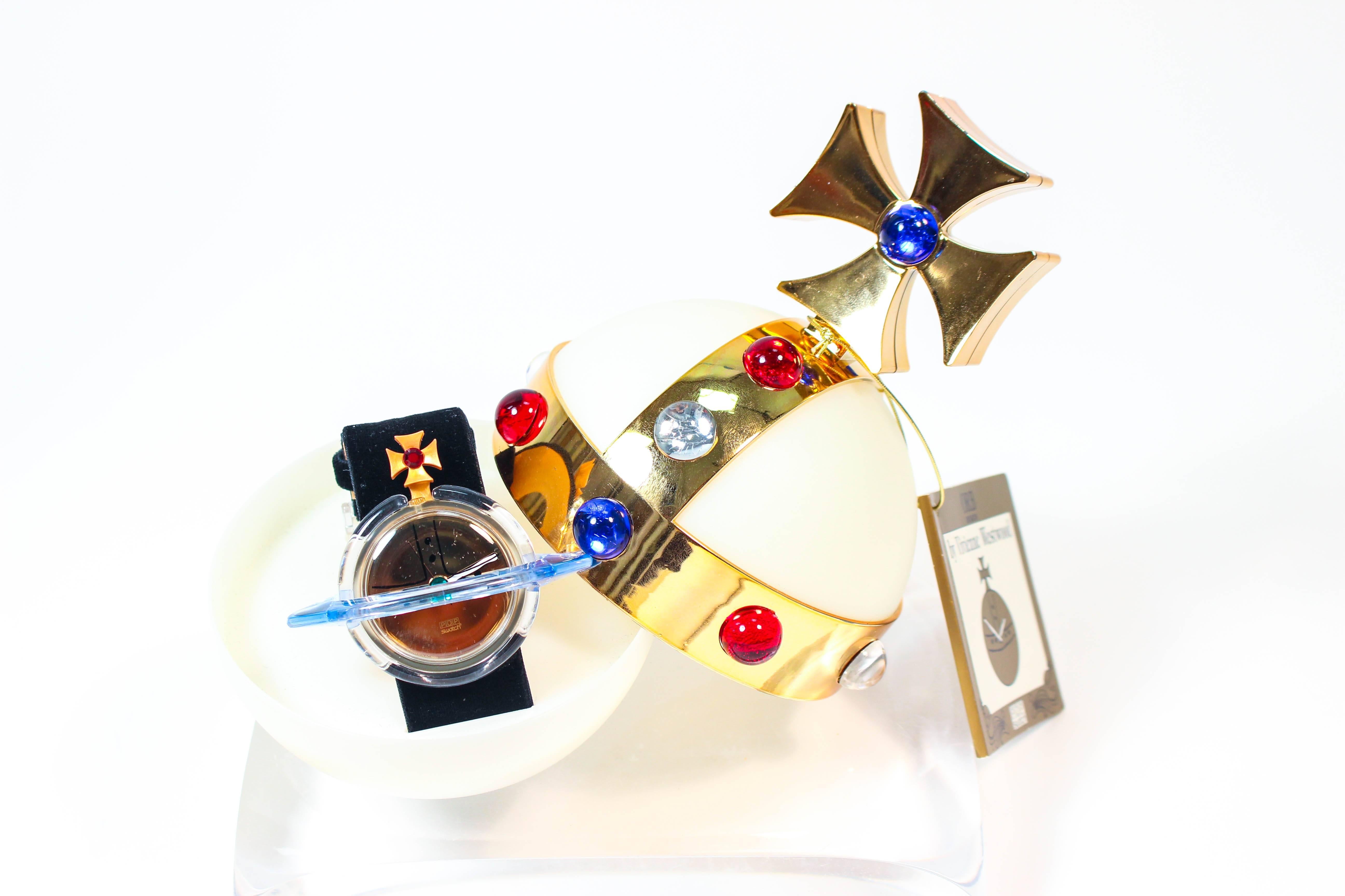This vintage Vivienne Westwood watch is by Swatch. Features an Orb holder with original box and paperwork. The watch has a plastic composition with black velvet band. In excellent unused vintage condition.

**Please cross-reference measurements for