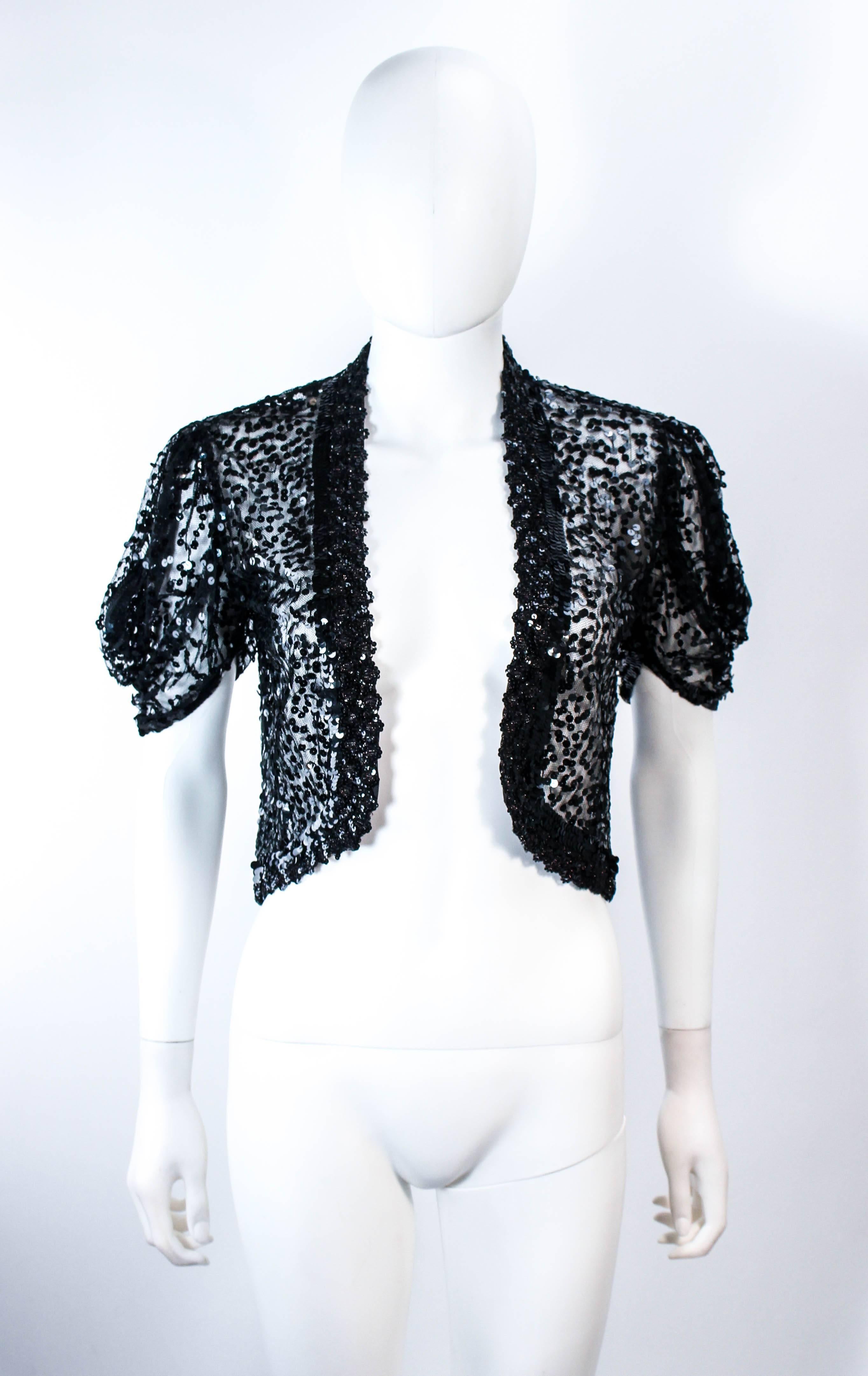 This antique jacket is composed of a sheer black mesh with black sequin applique. The sleeves have a functional zipper. Features an open style. In excellent vintage condition. 

**Please cross-reference measurements for personal accuracy. Size in