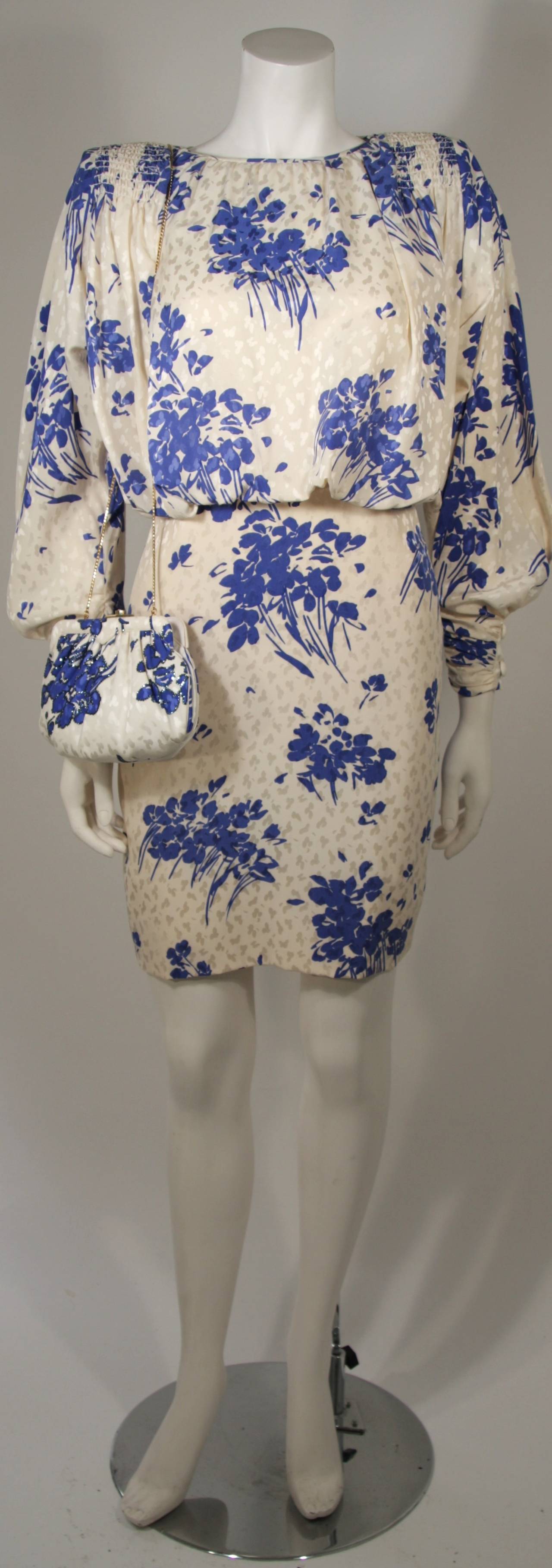 This  Galanos dress with the matching Judith Leiber purse is available for viewing at our Beverly Hills Boutique. The dress is fashioned out of a patterned silk and features smocking at the shoulders and back. There is a center back zipper closure.