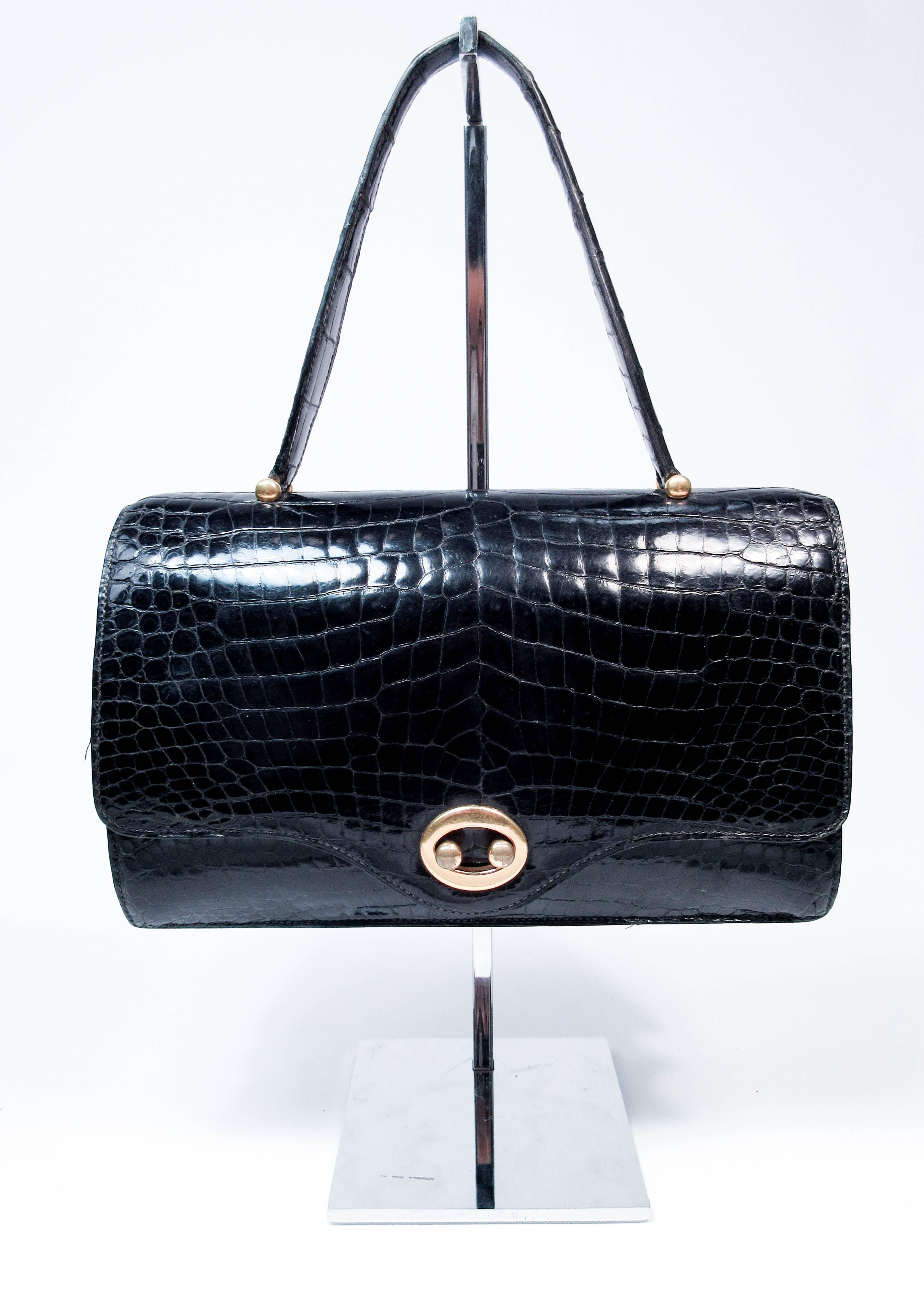 This Hermes purse is composed of a stunning black crocodile and features gold hardware with a top handle design. There are multiple interior compartments. In excellent pre-owned vintage condition. Made in France.

**Please cross-reference