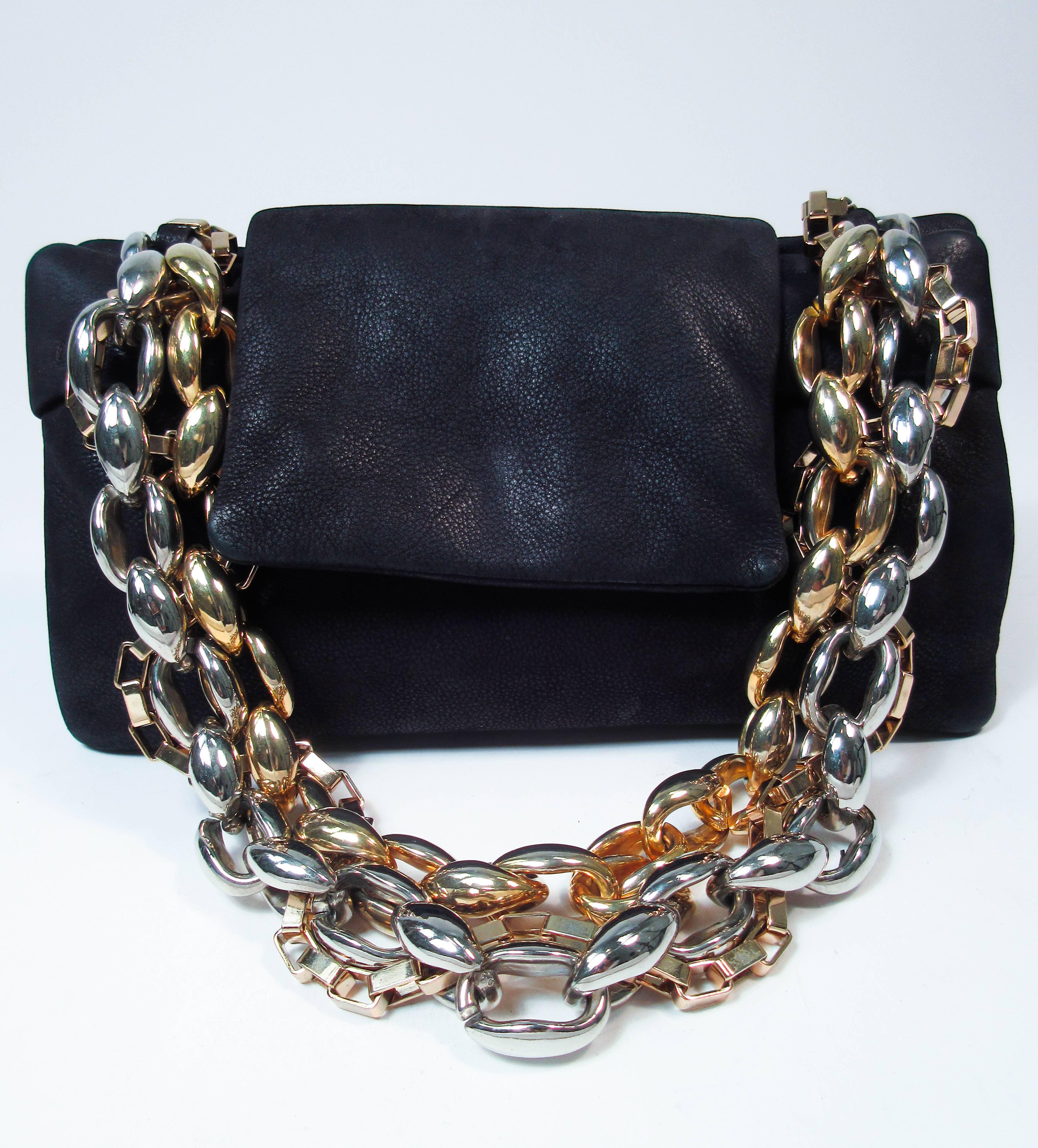 This Paule Ka design is composed of a supple black pig skin. Features a multi-hue chain strap with magnetic closure, and flip open style. There is an interior zipper compartment with mirror and multiple card holders. In excellent pre-owned condition