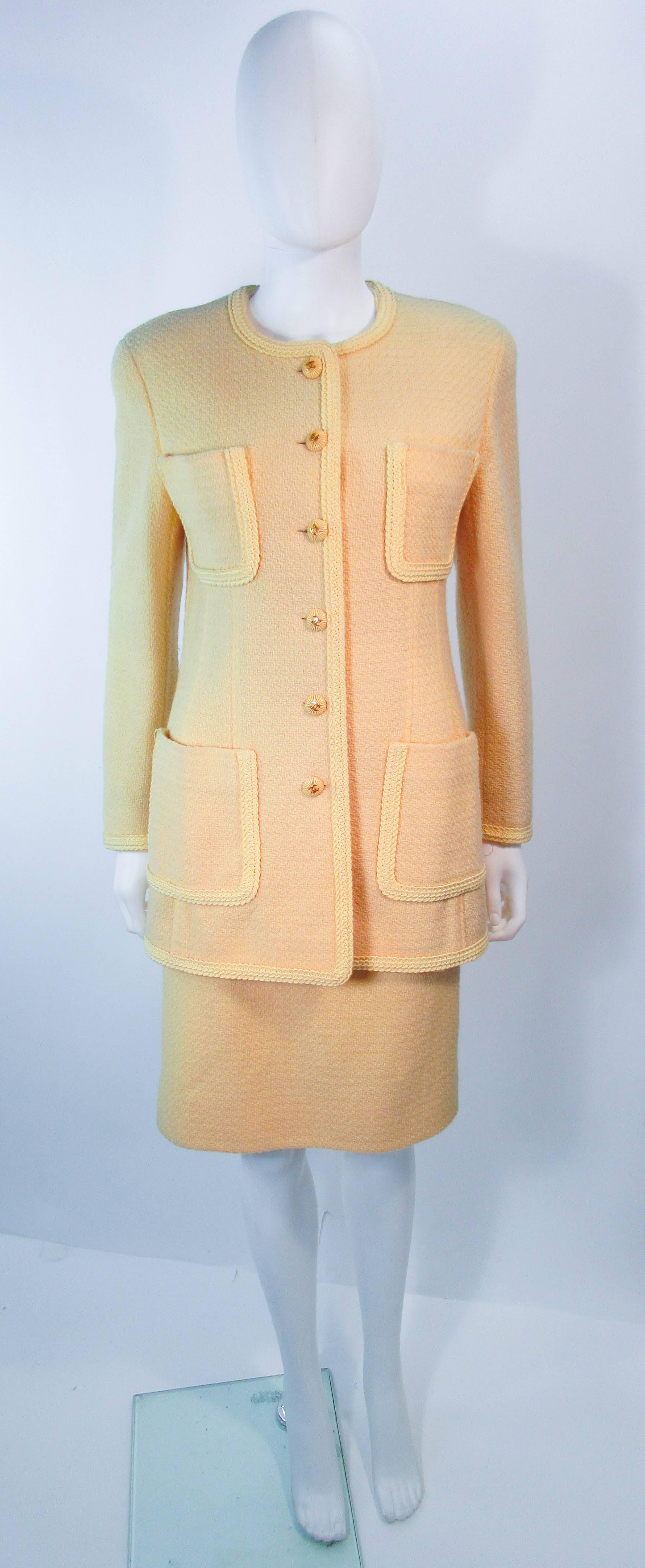 This Chanel skirt suit is composed of a yellow wool with textured yellow buttons with gold 'CC' logo buttons as well as a silk lining. The jacket features center front button closures and four front pockets. The classic pencil style skirt features a