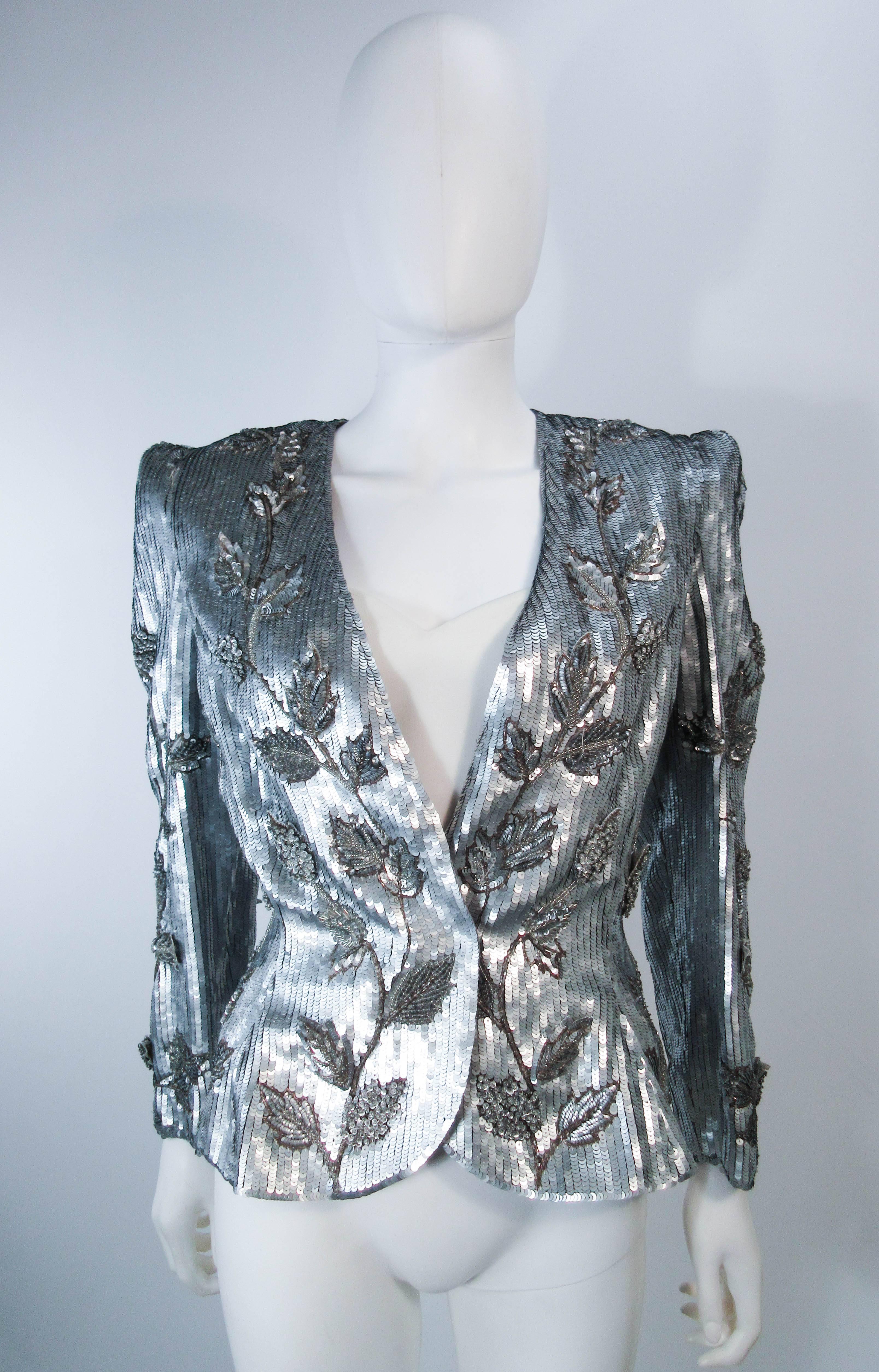 This Carolina Herrera jacket is composed of silver sequin and beaded fabric with a floral motif. Features center front hook and eye closures. The blouse has a zipper closure. In excellent vintage condition. 

  **Please cross-reference measurements