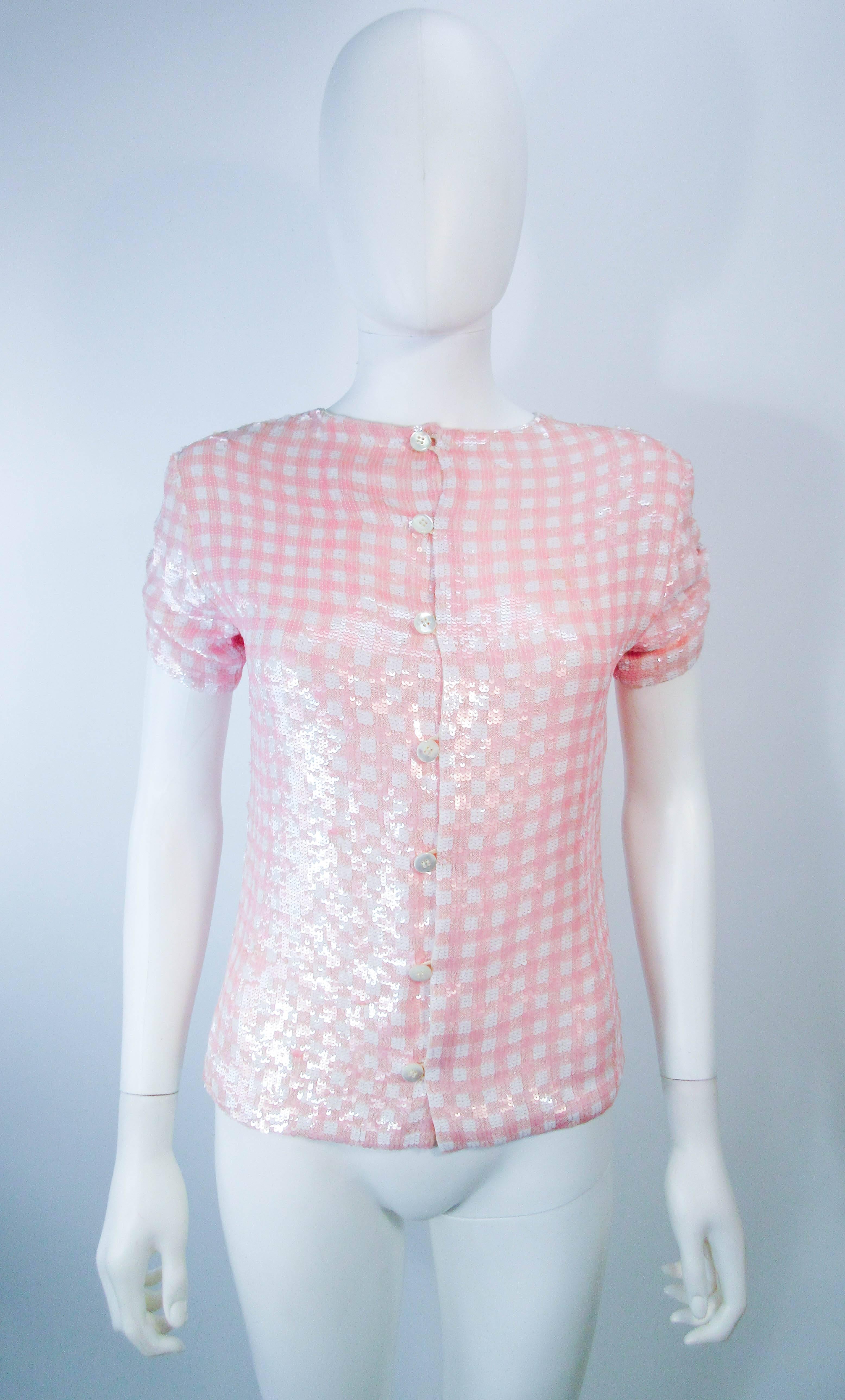 This Bill Blass blouse is composed of pink and white sequins. Features center front buttons, and a gathered sleeve design. In excellent vintage condition (shows some signs of wear due to wear).

  **Please cross-reference measurements for personal
