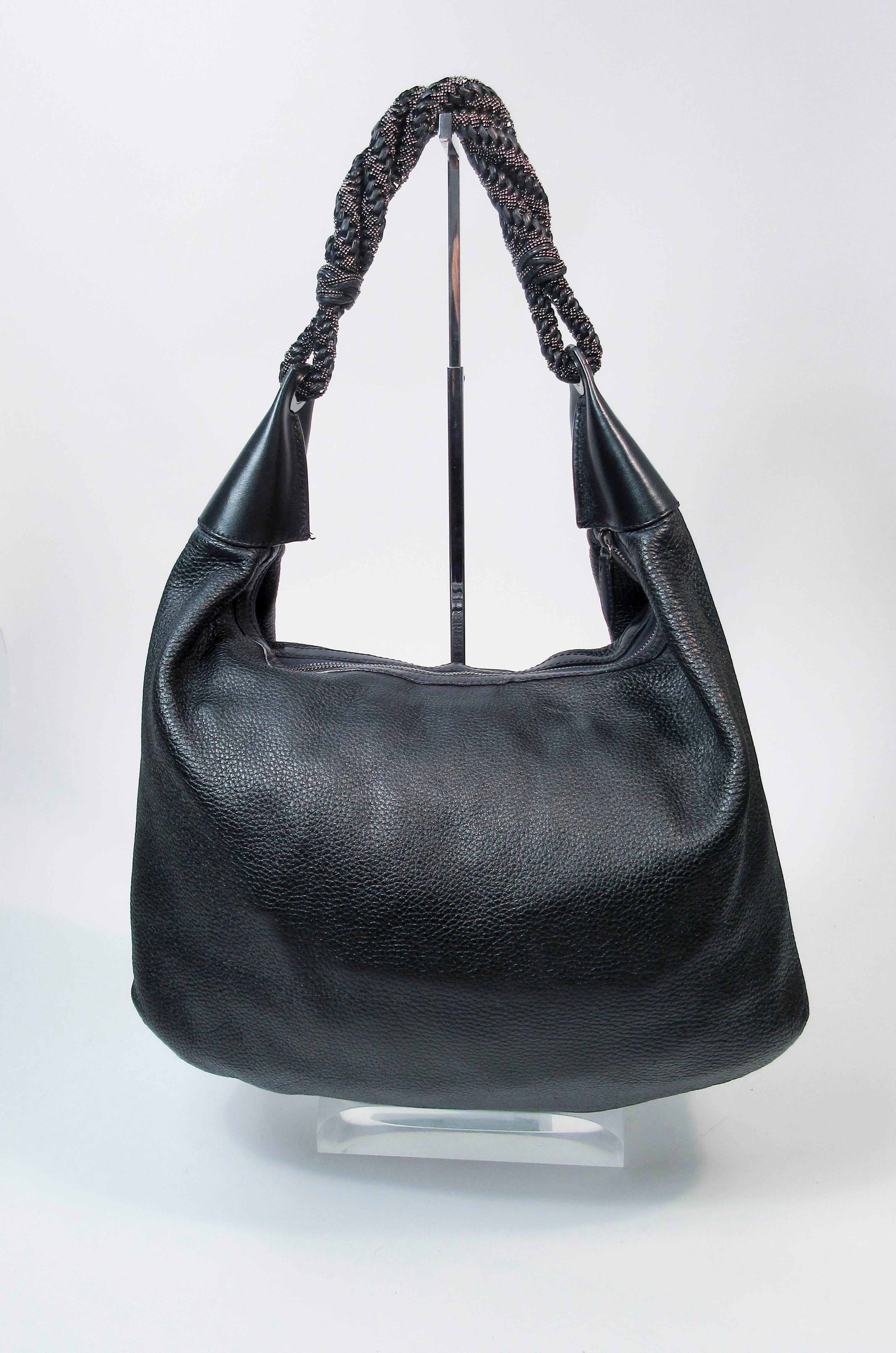 This Oscar De La Renta purse is composed of a beautiful Black leather. Features a hobo shape with a gorgeous beaded strap in black and gunmetal hues. There is an interior zipper pocket and comes with dustbag. In excellent pre-owned condition (some