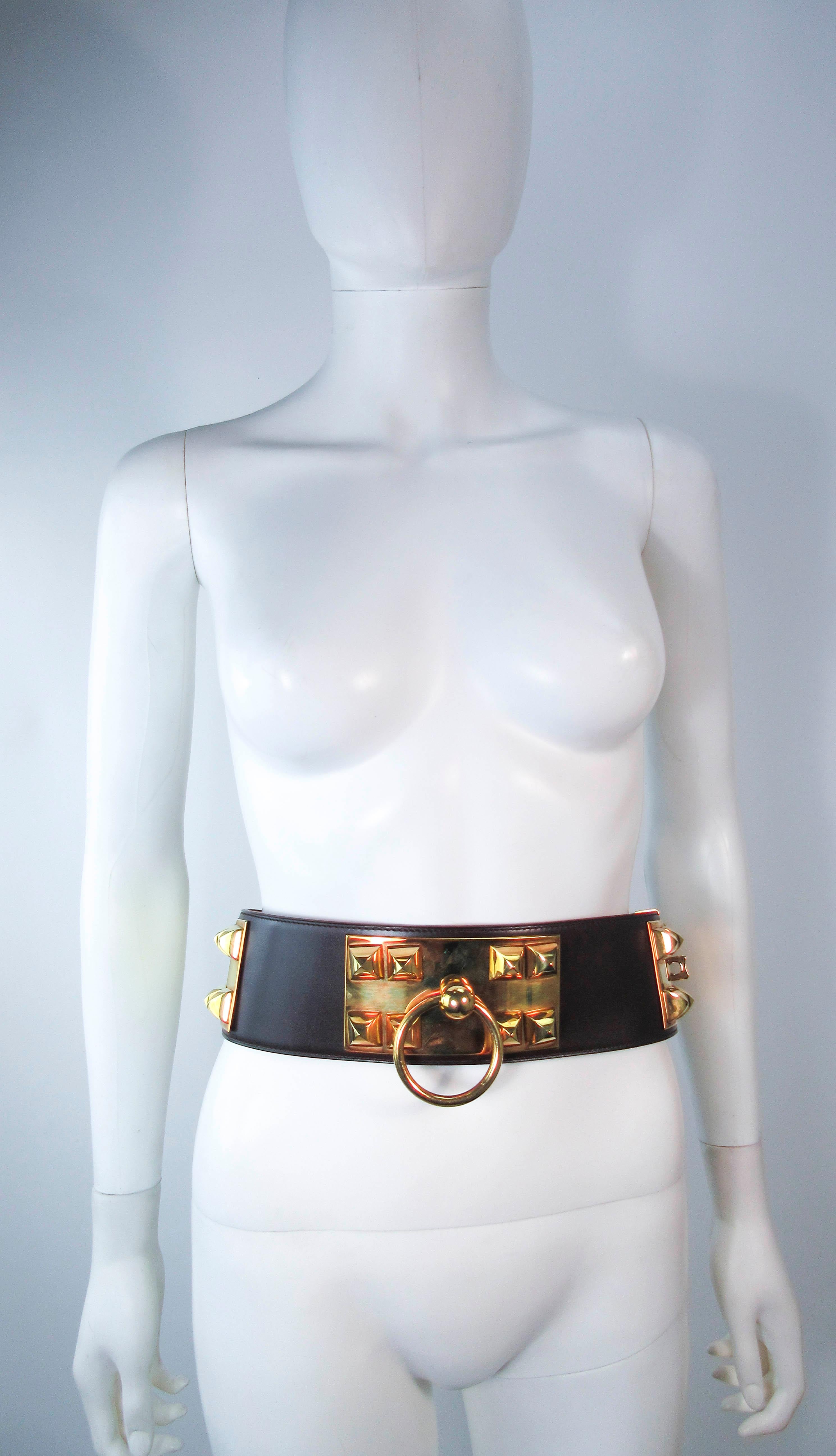This vintage Hermes belt is composed of a brown leather with gold hardware. Features a turn-lock closure with a large circle accents. This is a fantastic statement piece and excellent addition to any collectors wardrobe. In excellent pre-owned