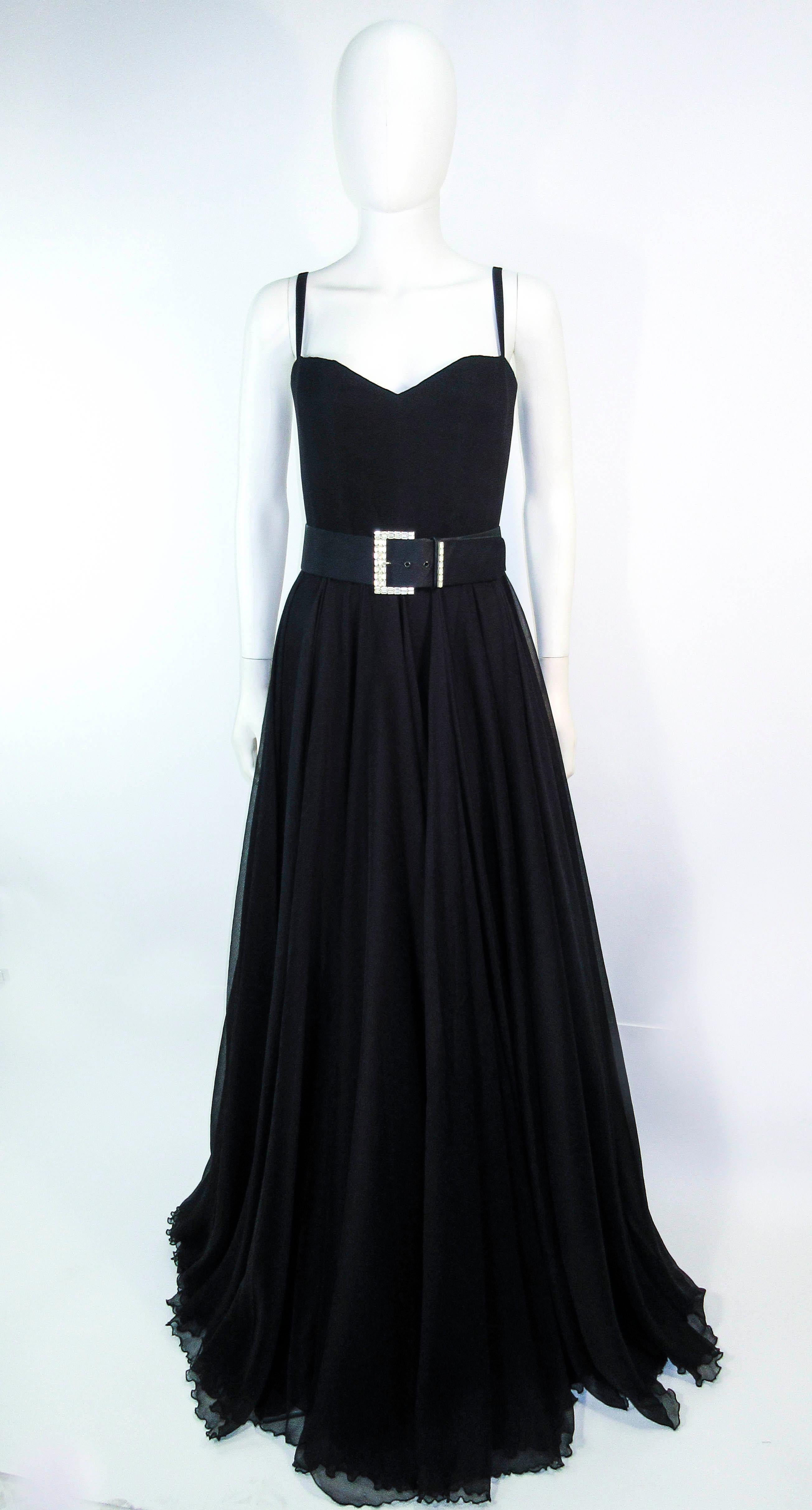 This Elizabeth Mason Couture gown is composed of a sweeping black silk chiffon. This striking gown is composed of approximately 50 yards of silk chiffon. The bodice features a simple, sleek, and classic boned interior with a center back zipper