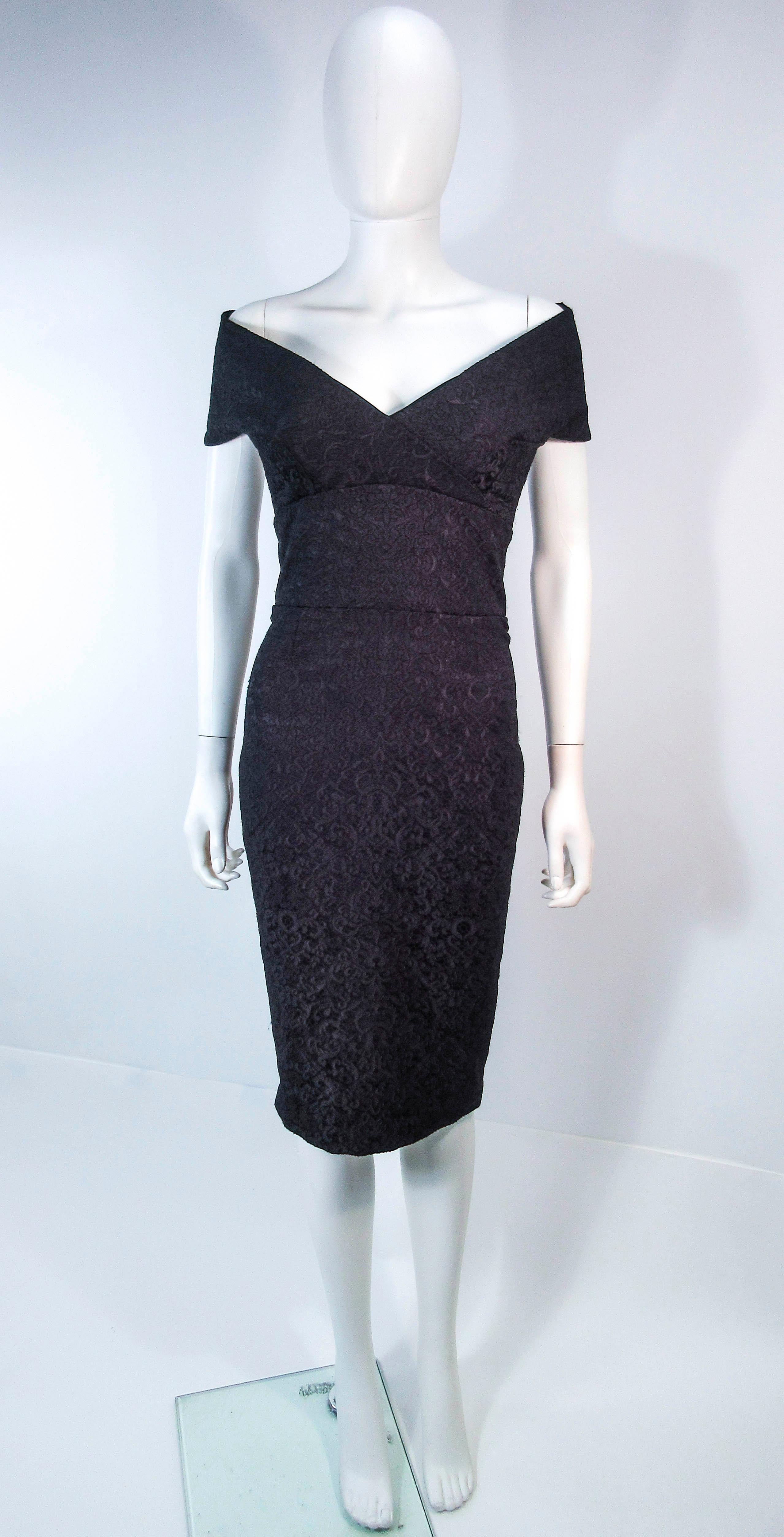 This Elizabeth Mason Couture cocktail dress is composed of a stretch brocade. This fabric is one of a kind, and can be made to order in a variety of fabrics. This halter unique halter style features a nipped waist with a sleek pencil silhouette, and