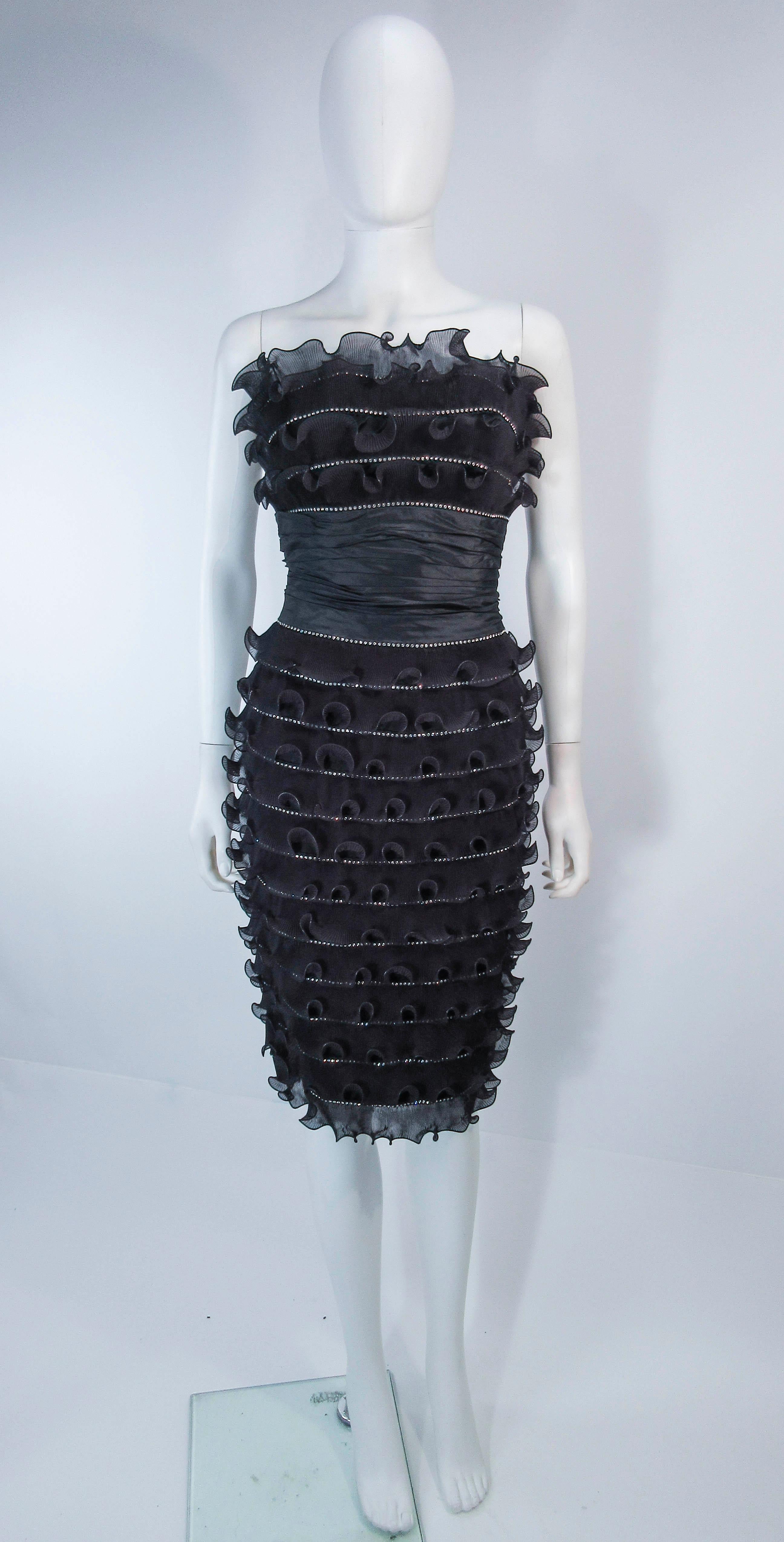 This Jiki Monte-Carlo Creation is composed of black pleated ruffles with rhinestone trim. This is an absolutely stunning strapless cocktail design a knee length with ruched waist. There is a center back zipper closure. In excellent vintage