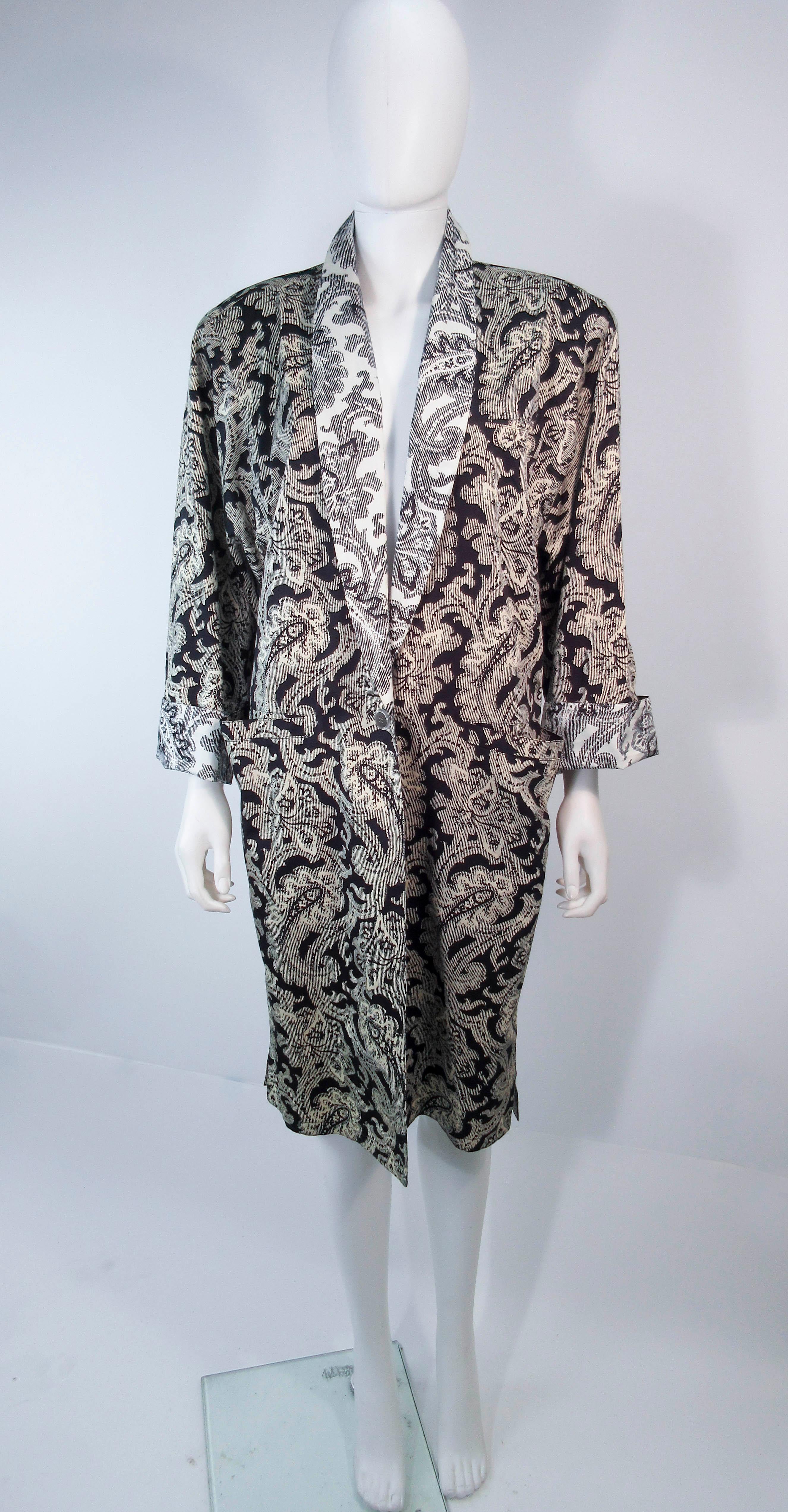This vintage Versace coat is composed of a light weight black & white Venetian print textile. Features a center front button closure & pockets. In excellent vintage pre-owned condition, some discoloration (see photos). 

**Please cross-reference
