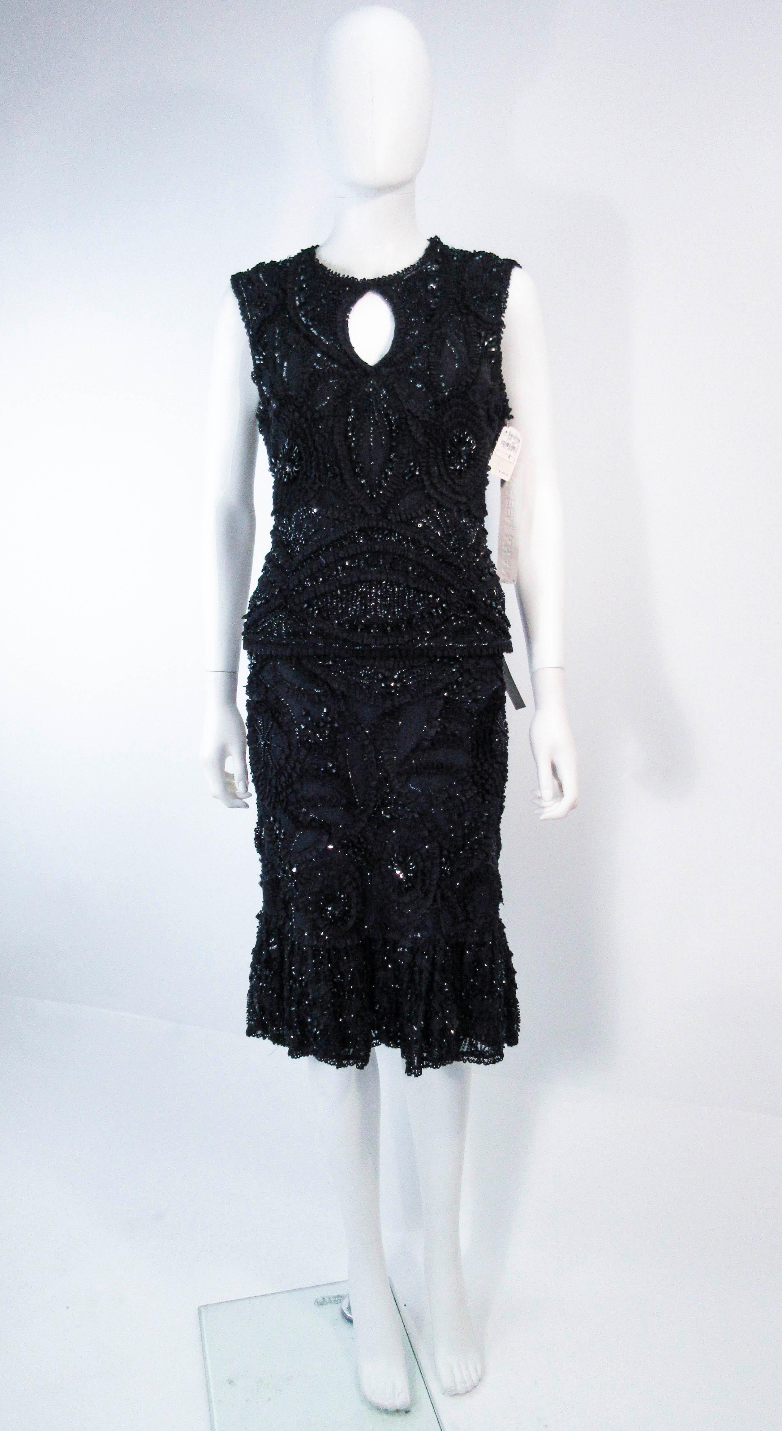 This Naeem Khan set is composed of a black stretch knit with black sequin & bead applique. The blouse features a keyhole design and the skirt has a wonderful flare shape. In excellent 'like new' condition with original price tags. 

**Please