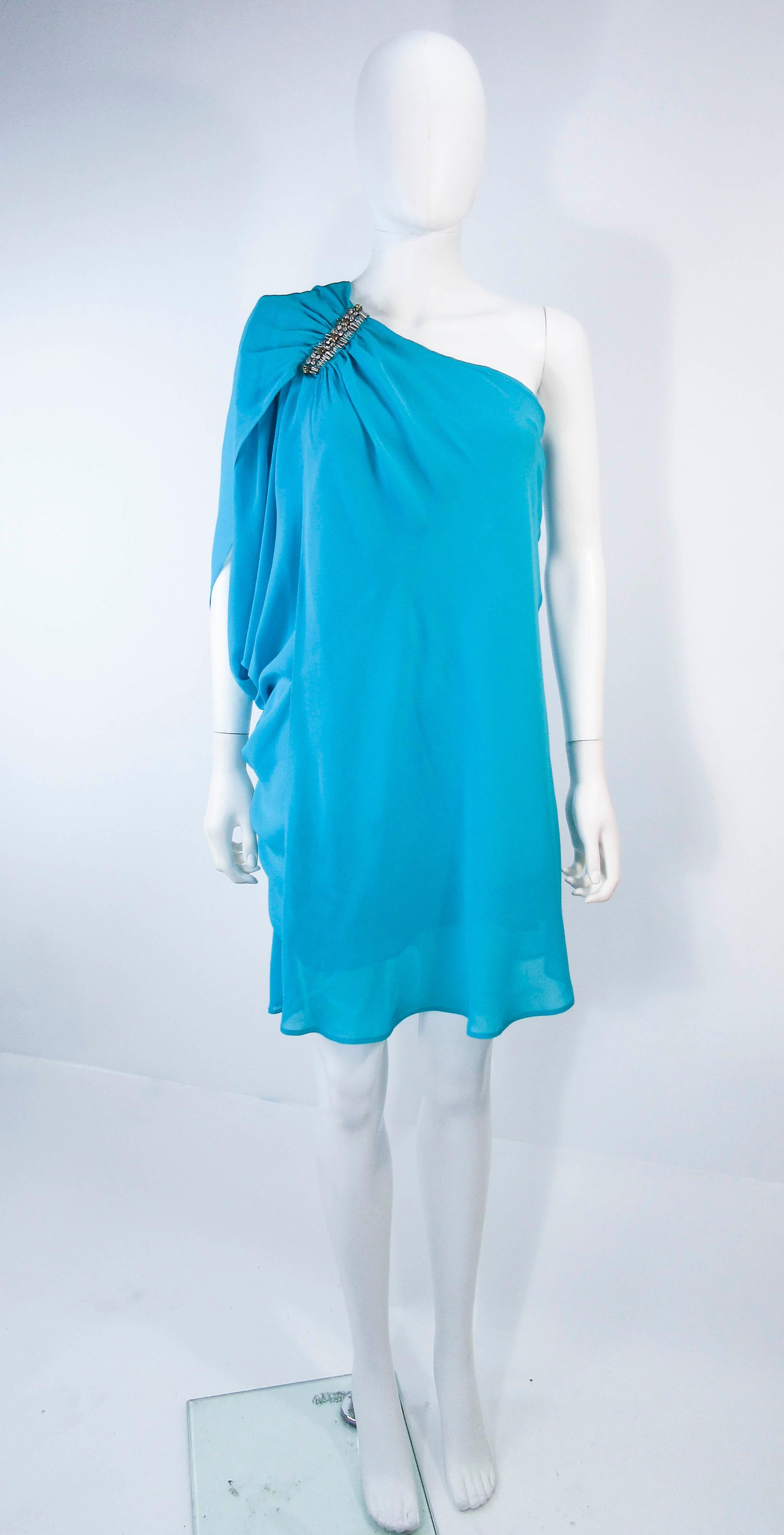 This Roberto Cavalli dress is composed of a aqua silk chiffon. Features an asymmetrical one shoulder design with beaded applique. There is a side zipper closure. In excellent pre-owned condition, some wear and a pull (see photos). 

**Please