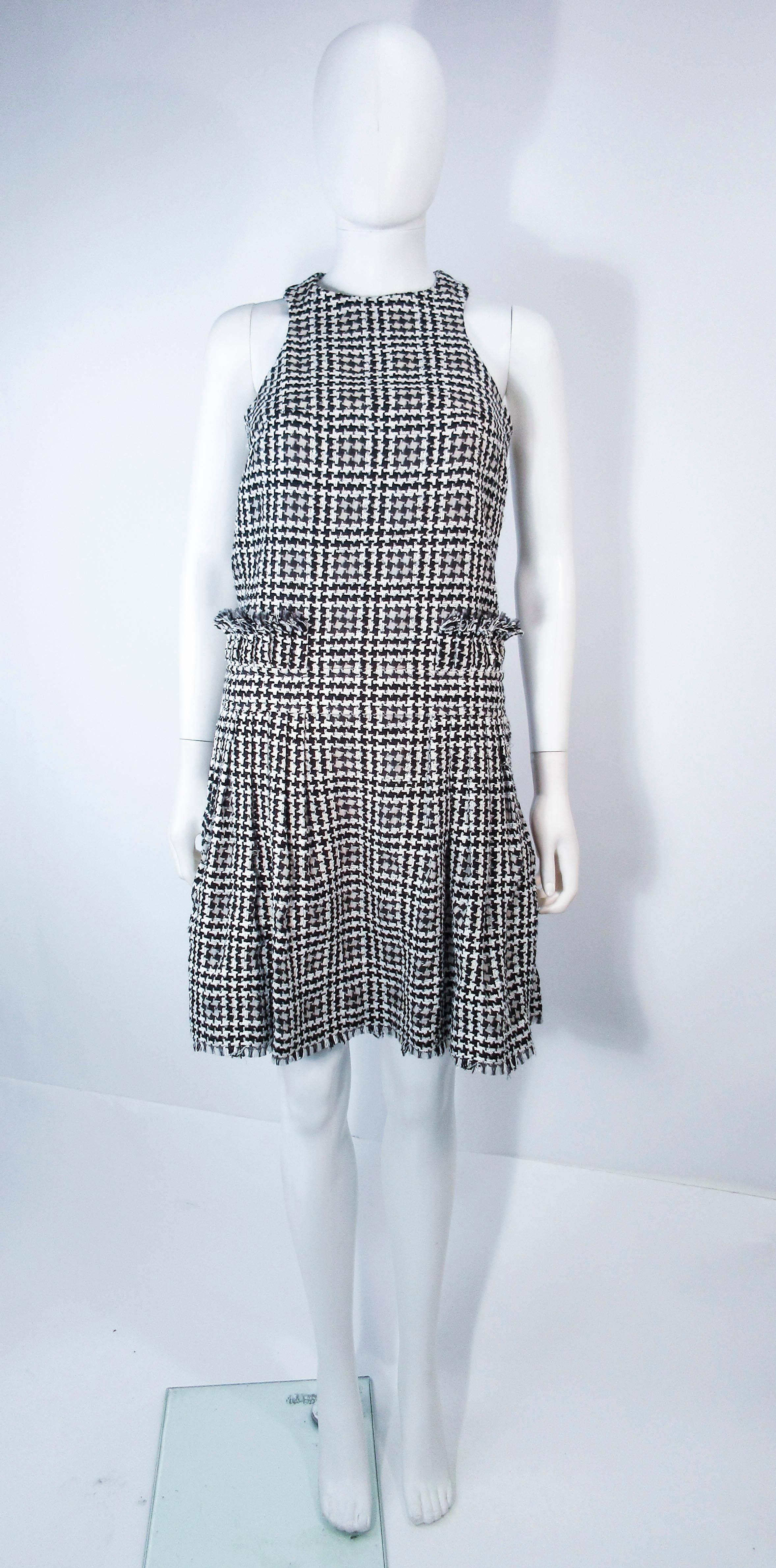This Chanel dress is composed of black & white tweed. Features a criss cross back with frayed waist accents. There are buttons at the shoulders. In excellent vintage condition.

**Please cross-reference measurements for personal accuracy. Size in
