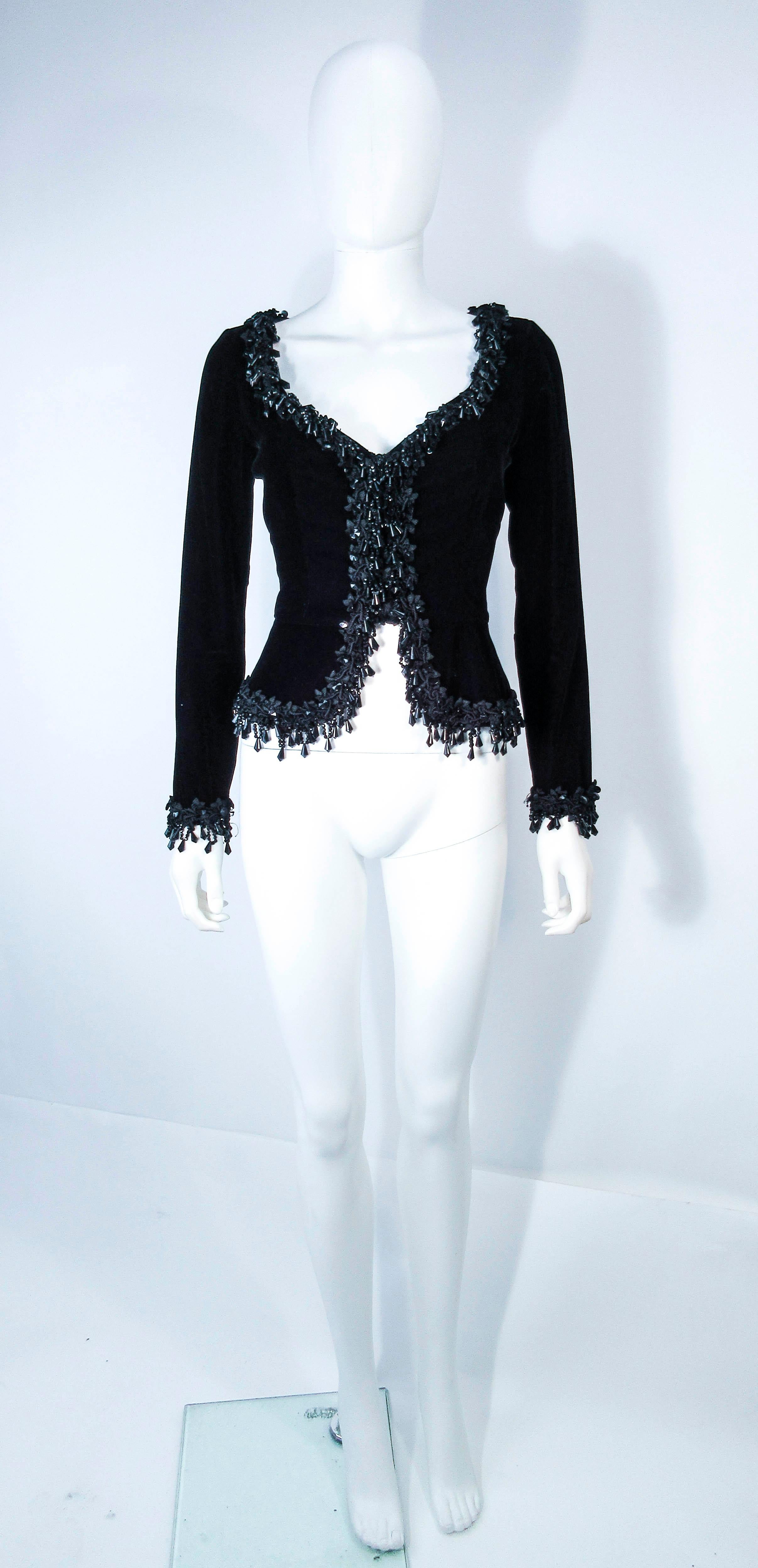This Victor Costa jacket is composed of a black velvet. Features cascading beading throughout the neckline and sleeve ends. There is a center front zipper closure. In excellent vintage condition, some light signs of wear due to age (please see