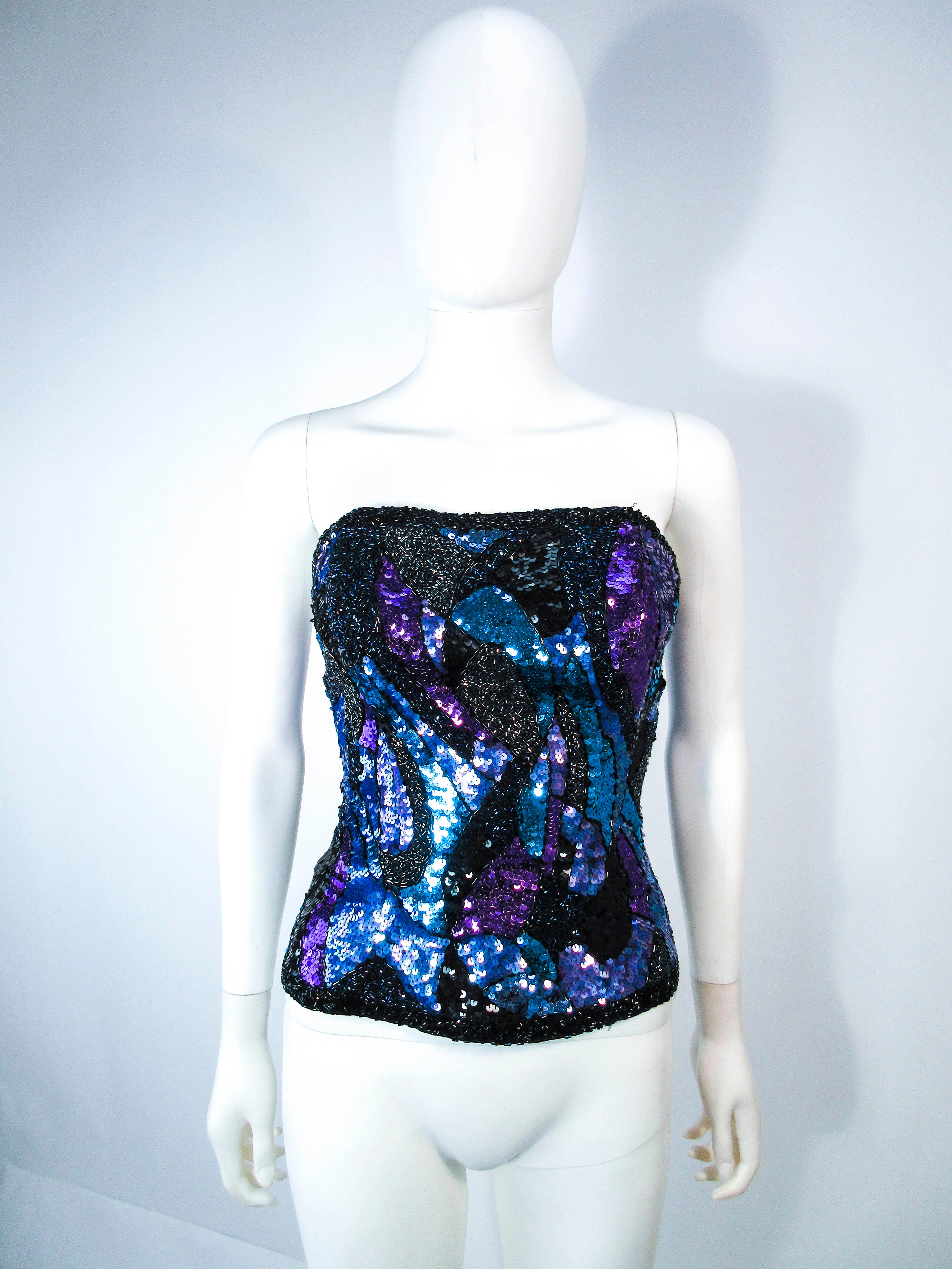 This vintage bustier is composed of an abstract sequin pattern, in blue, purple, and black with a beaded trim. Features a side zipper. In excellent vintage condition.

Jacket pictured with bustier is available for sale in a separate