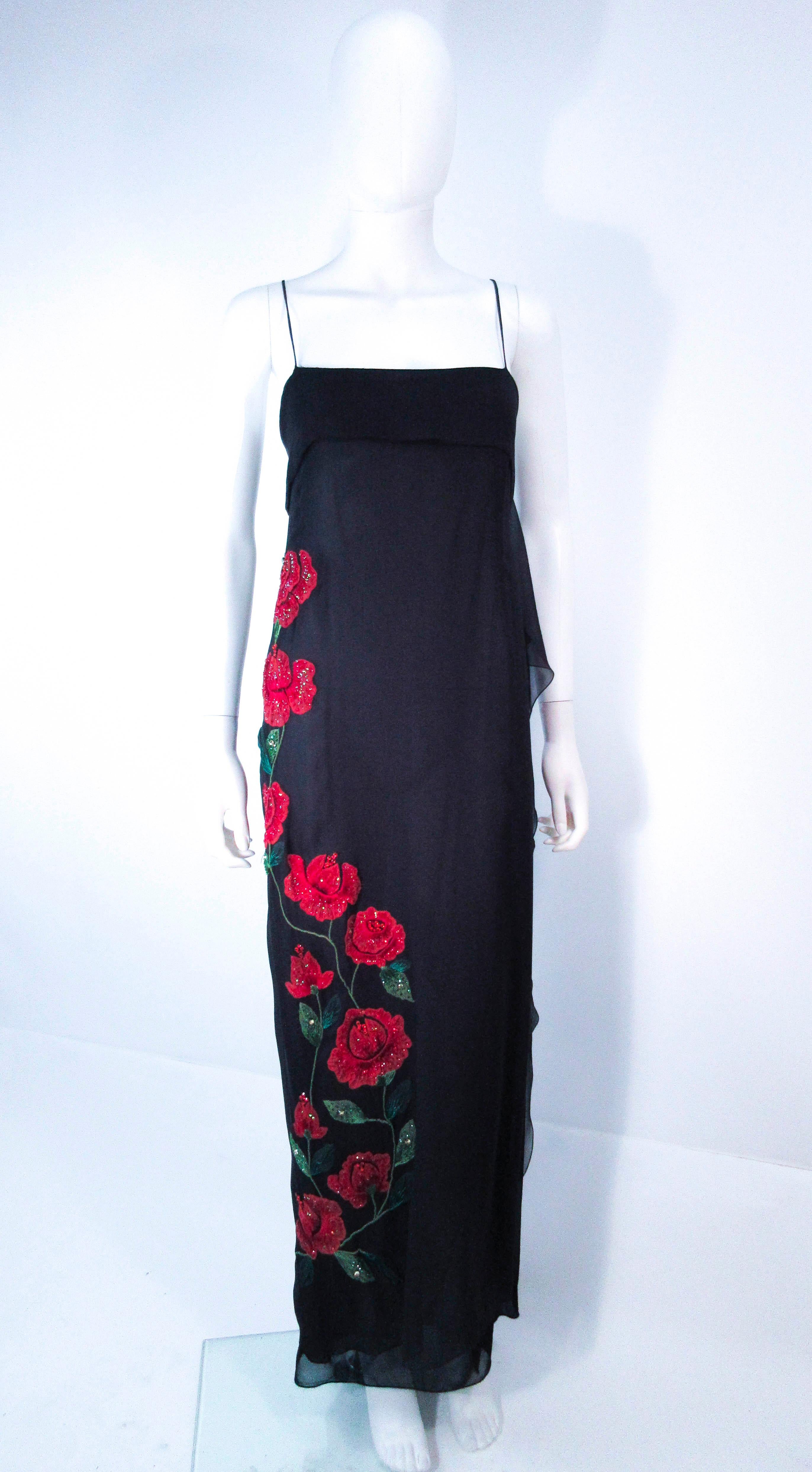 This Bluemarine gown is composed of a sheer black silk chiffon and features a beautiful side cascade with rose applique. There is a zipper closure. In excellent vintage condition (light signs of wear due to age, see photos, and two small mends which