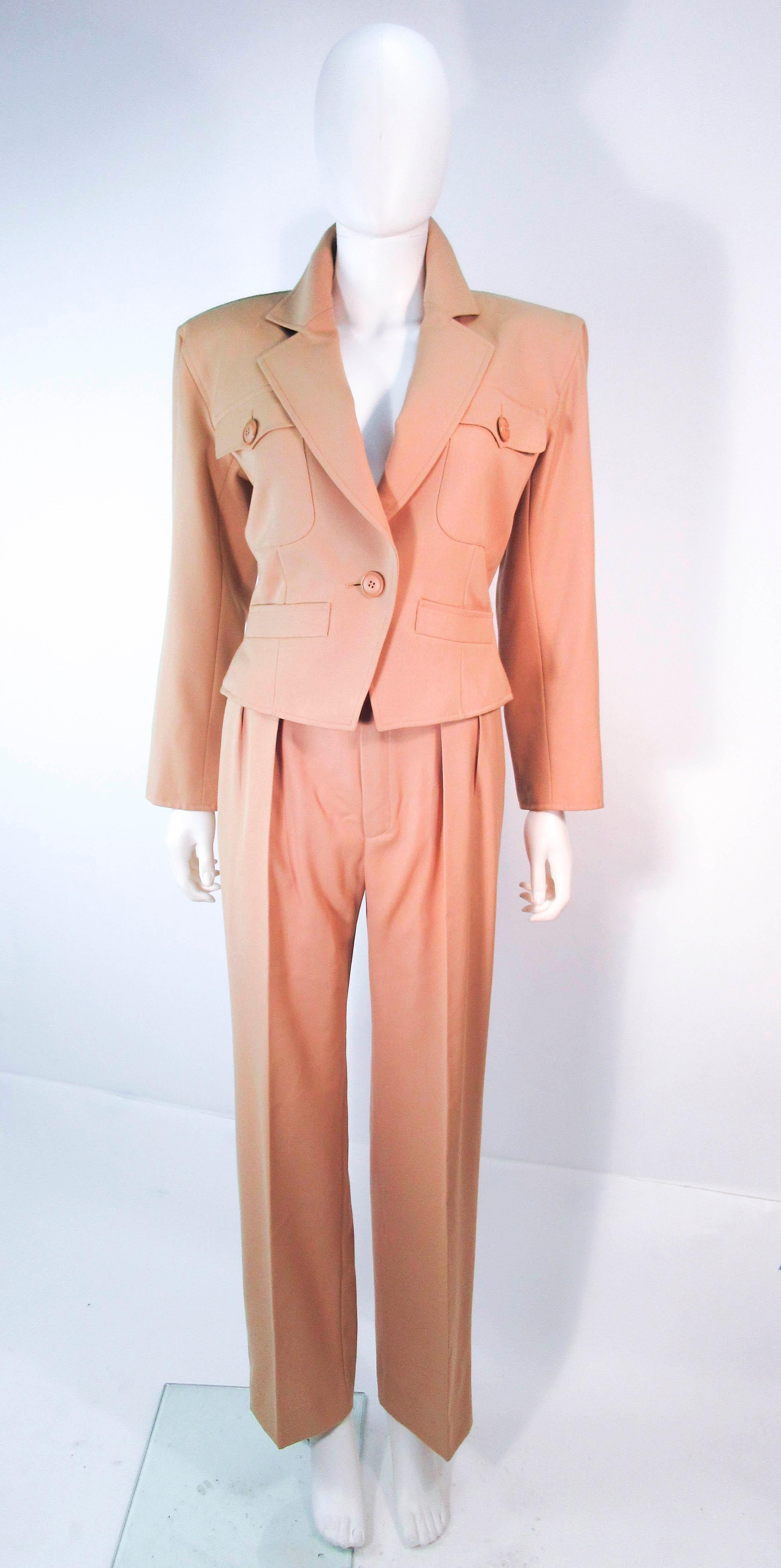 This Yves Saint Laurent suit is composed of a khaki wool. Features a classic YSL safari style with pleat front trousers and a classic pencil silhouette skirt. The jacket has center front button closures, while the pants and skirt have zipper
