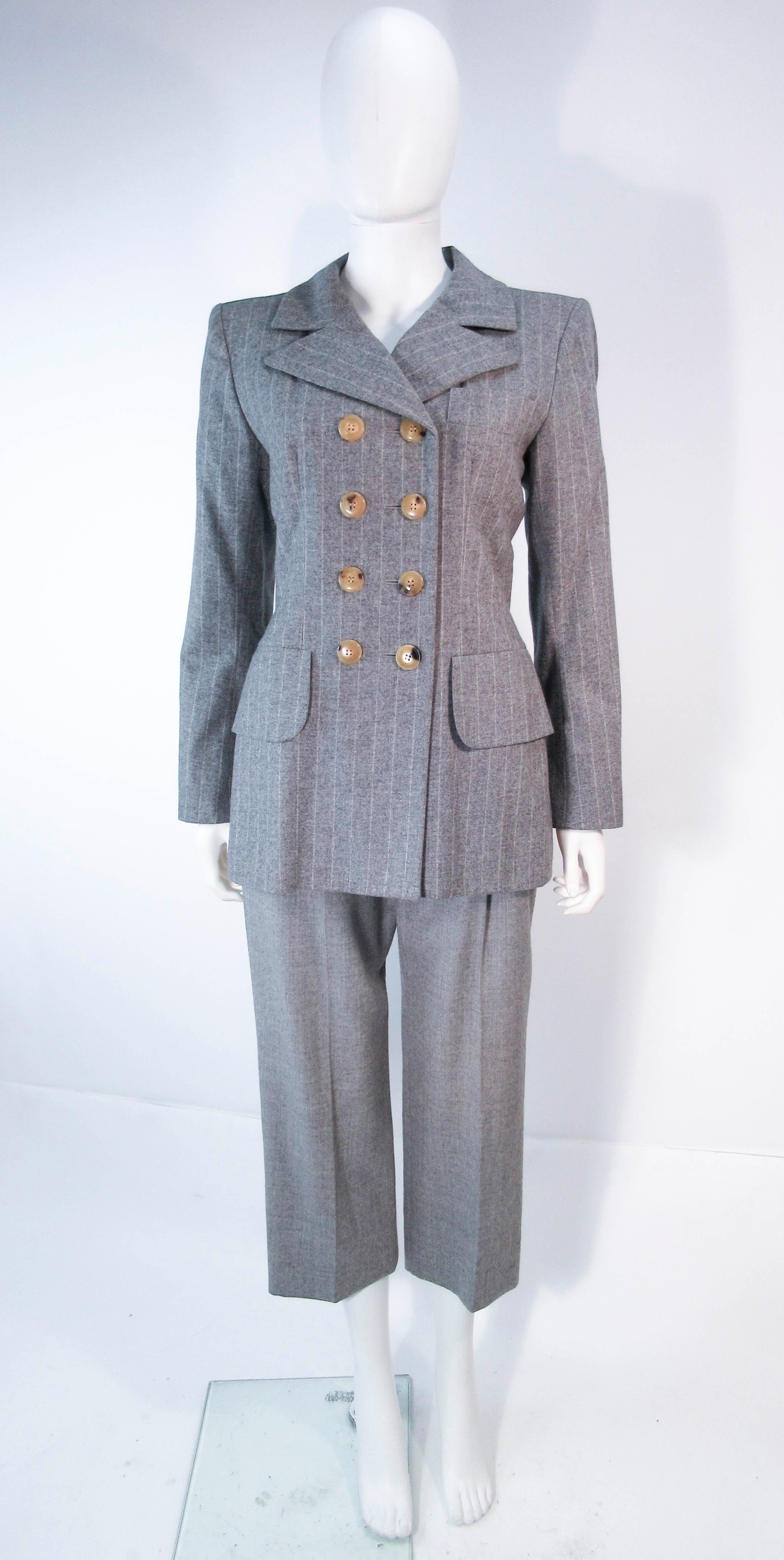 Ce costume Yves Saint Laurent est composé d'un mélange de laine grise. Comprend un magnifique blazer classique à double boutonnage et un magnifique pantalon court. En excellent état vintage (quelques signes d'usure dus à l'âge). Fabriqué en