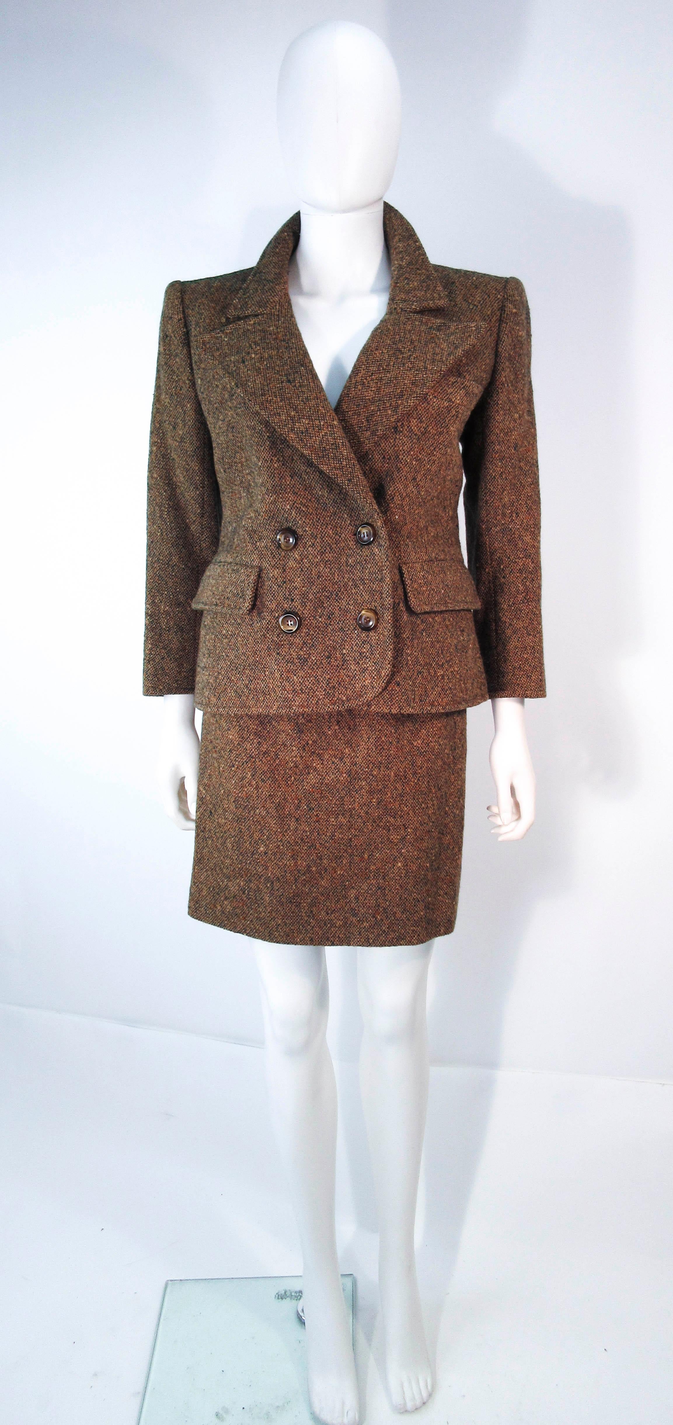 This Yves Saint Laurent suit is composed of a brown and green wool tweed. Features a beautiful classic double breasted blazer and a pencil skirt with zipper closure. In excellent vintage condition (some signs of wear due to age). Made in