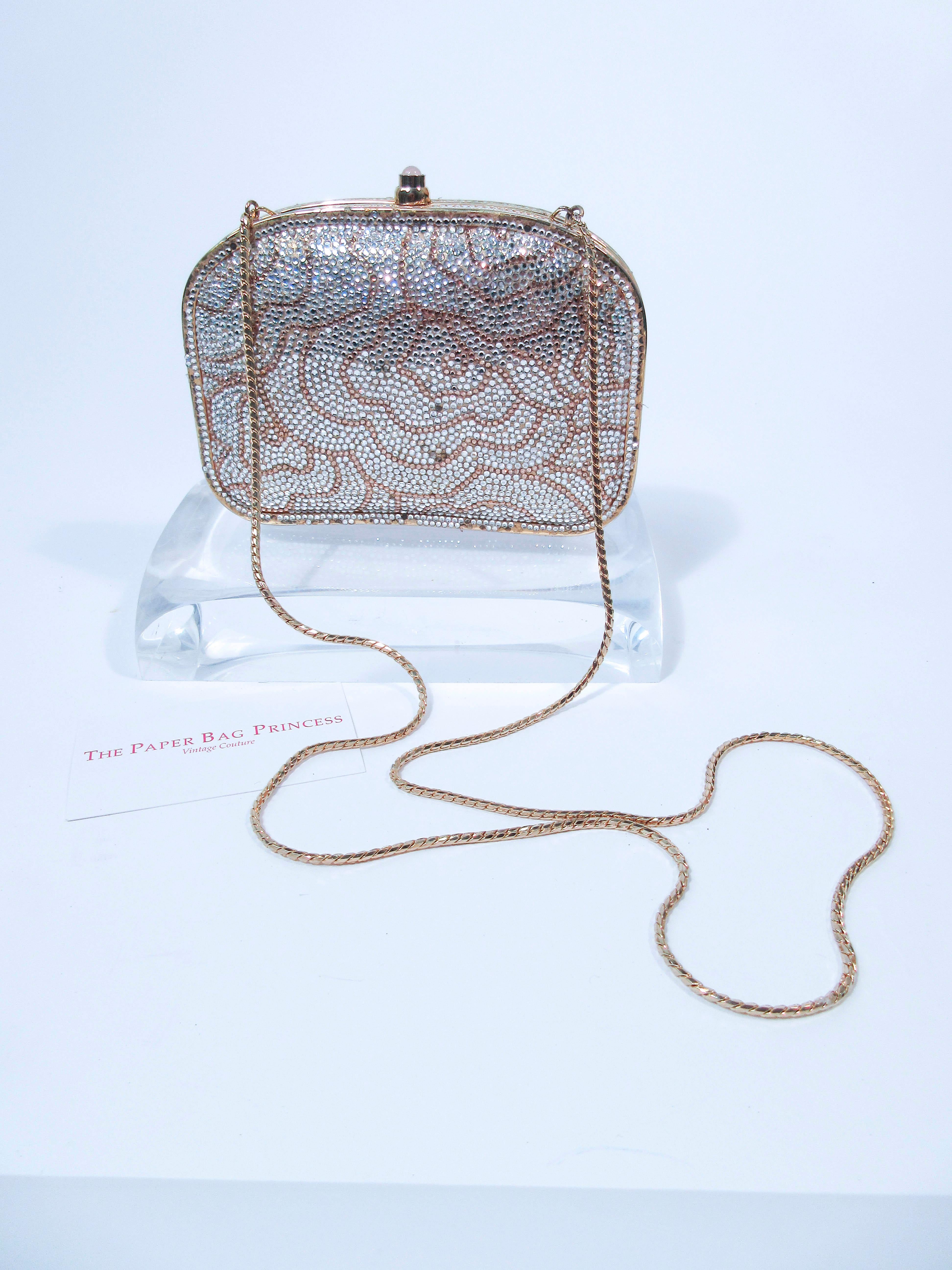 This Judith Leiber purse features a lovely floral pattern in white and gold rhinestone. There is a gold interior. In good vintage condition, there are some missing rhinestones and slight (See photos). Sold 