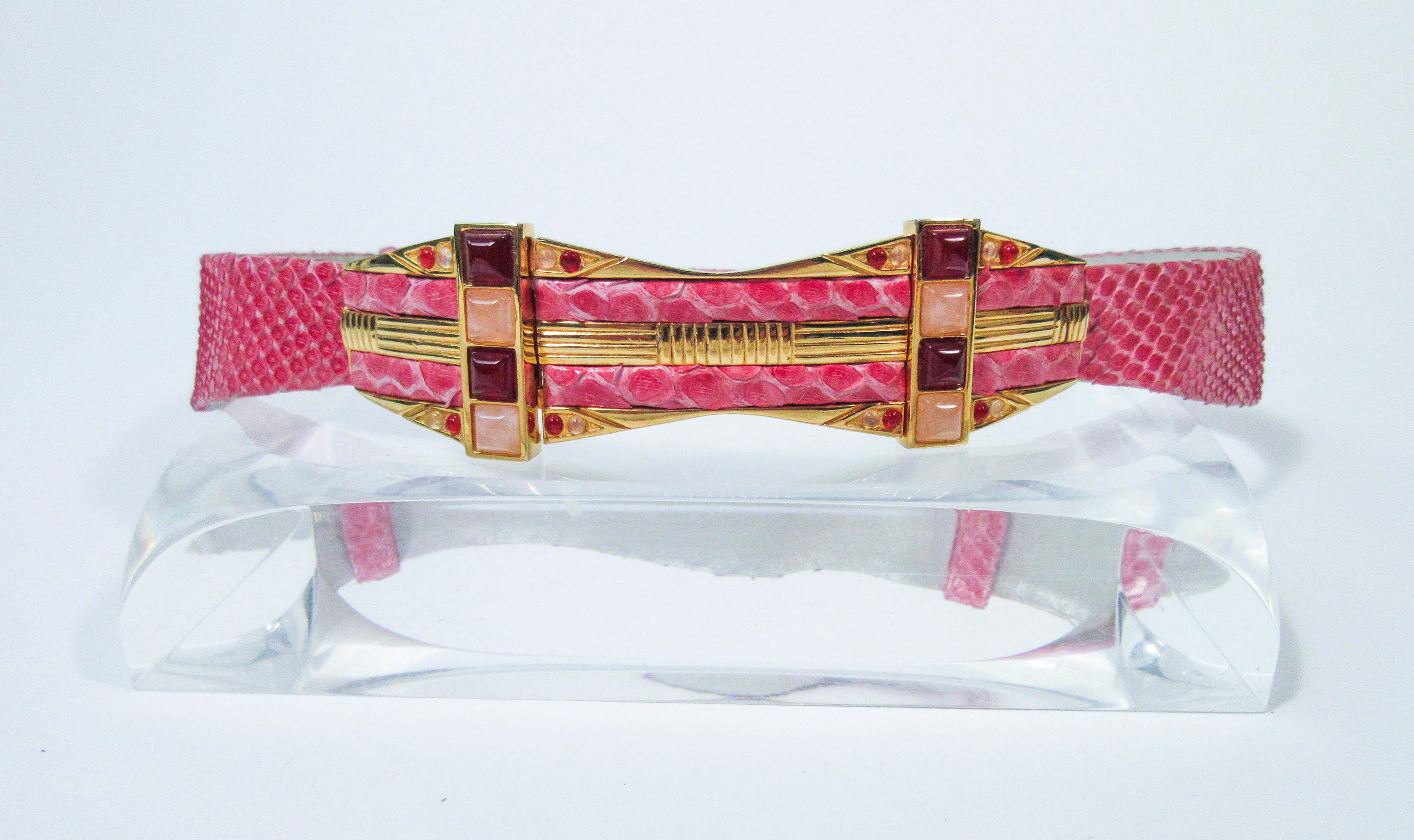This Judith Leiber belt is composed of a pink snakeskin. Features an adjustable design with cabochon set stones. In excellent 'like new' pre-owned condition (some signs of wear due to age, see photos). Sold 