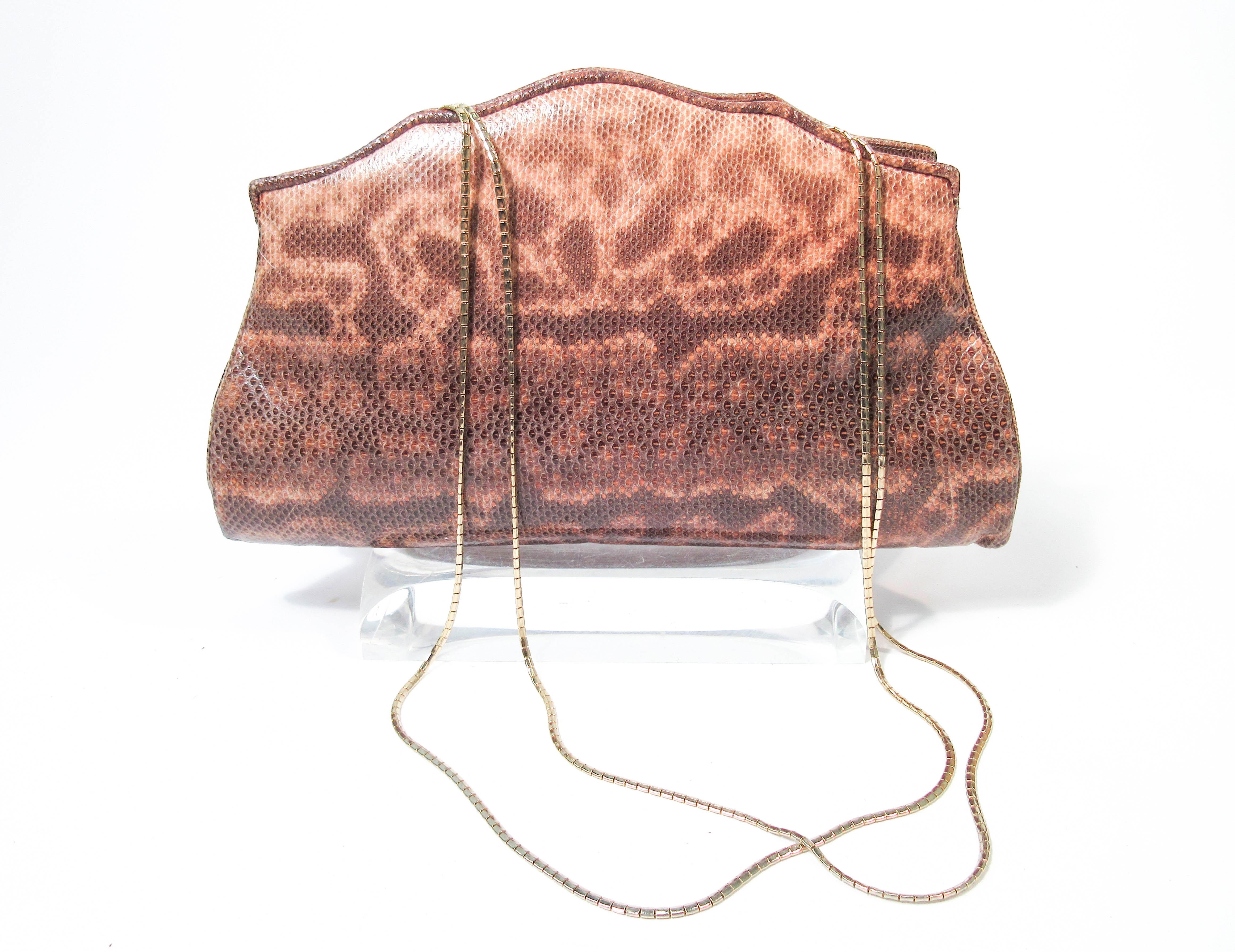 This Judith Leiber purse is composed of a nude to brown ombre lizard skin. Features an interior gold frame with two side pockets. There is an interior pocket and two slide pockets. Comes with coin purse and sleeper pouch. In great vintage condition