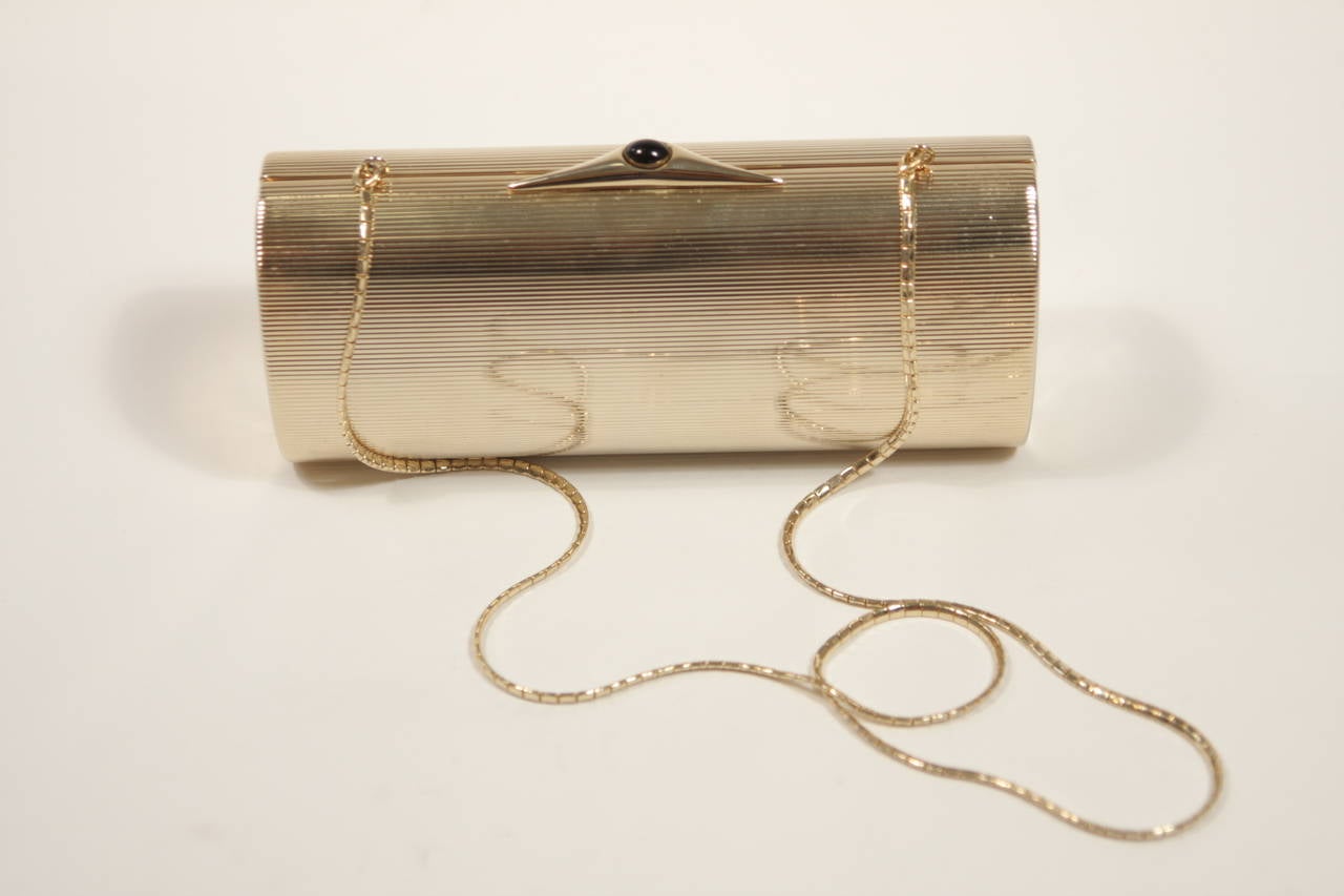 This Judith Leiber design is available for viewing at our Beverly Hills Boutique. We offer a large selection of evening gowns and luxury garments.

This evening clutch is composed of a ribbed gold metal and features a jewel accent closure. Comes